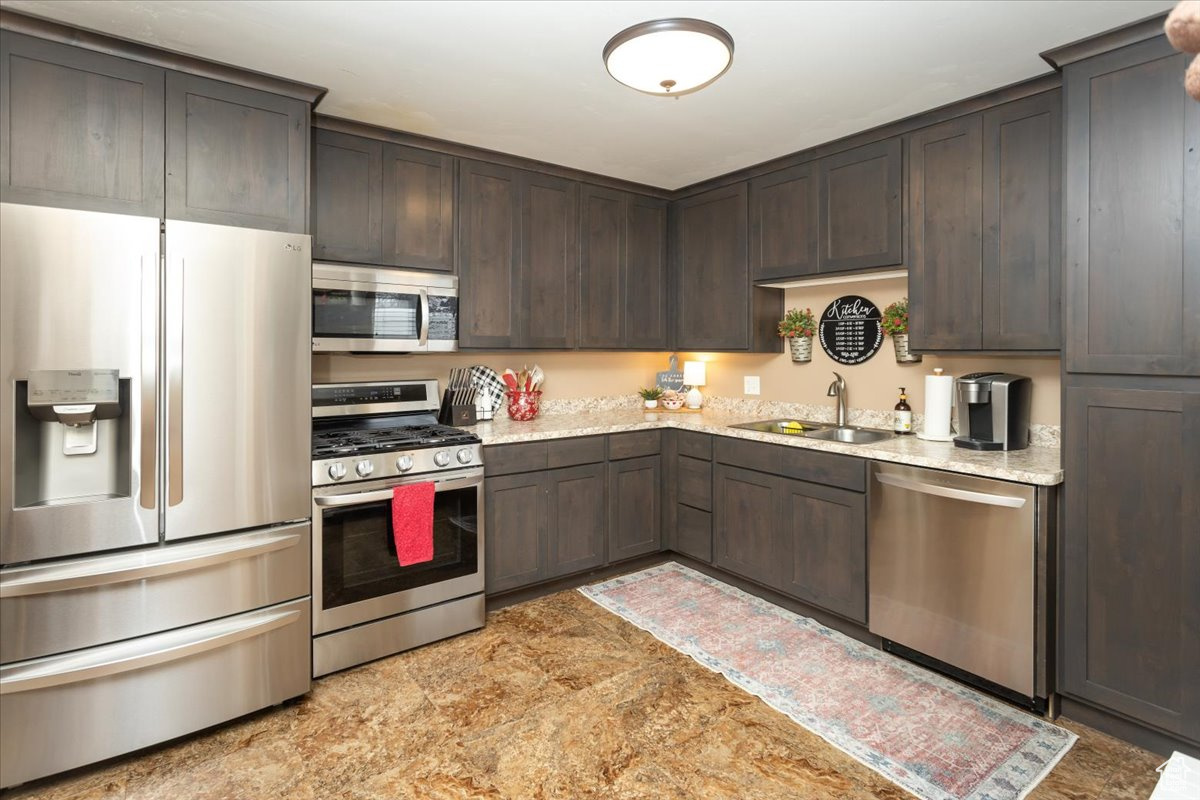 Kitchen with dark brown cabinetry, stainless steel appliances, and sink