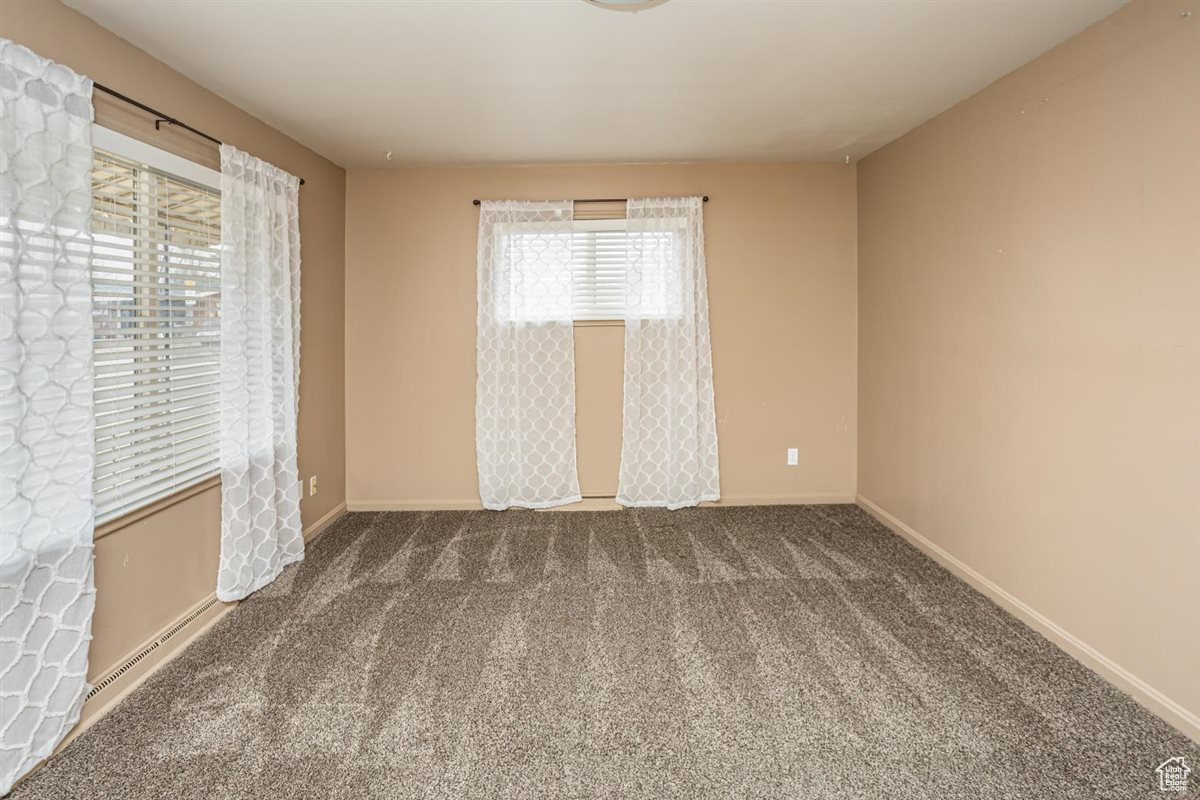 Carpeted spare room with baseboards