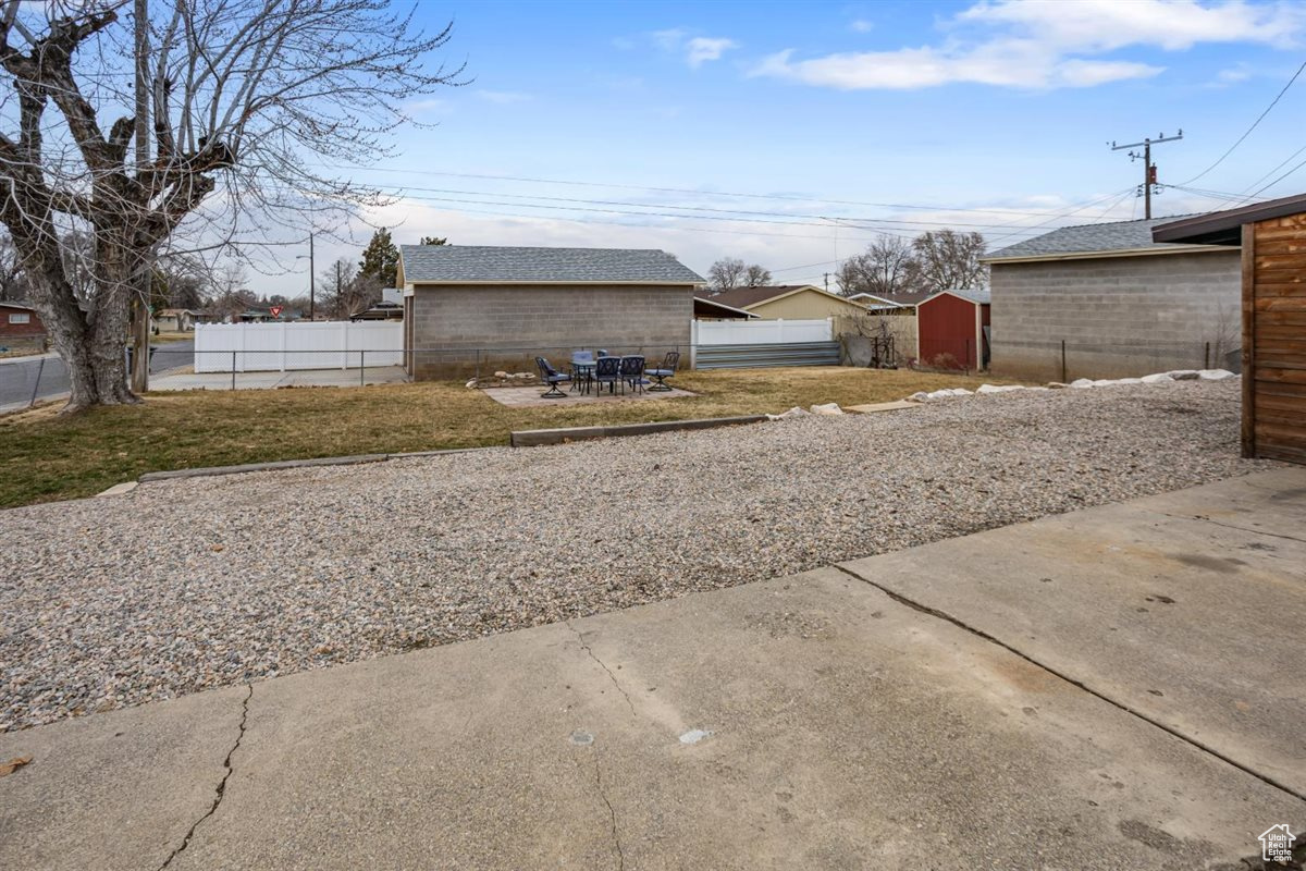 View of yard featuring an outdoor structure and fence