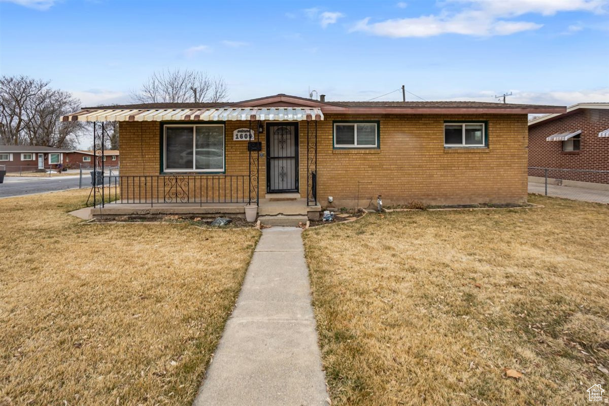 View of front of home featuring a front lawn and brick siding