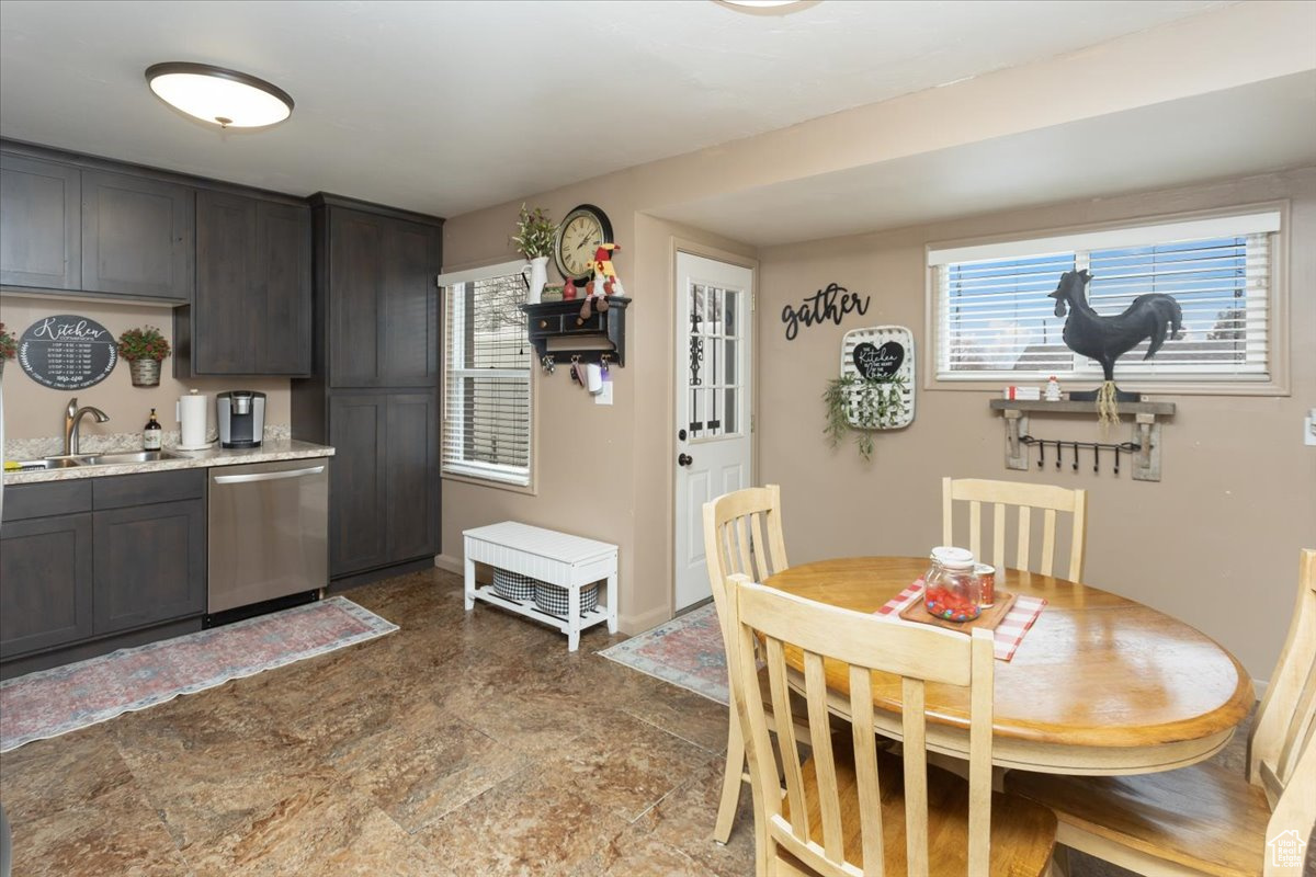 Kitchen featuring dark brown cabinetry, sink, a healthy amount of sunlight, and dishwasher