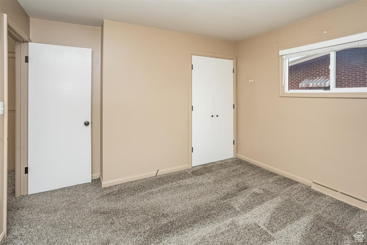 Unfurnished bedroom with carpet floors and baseboards