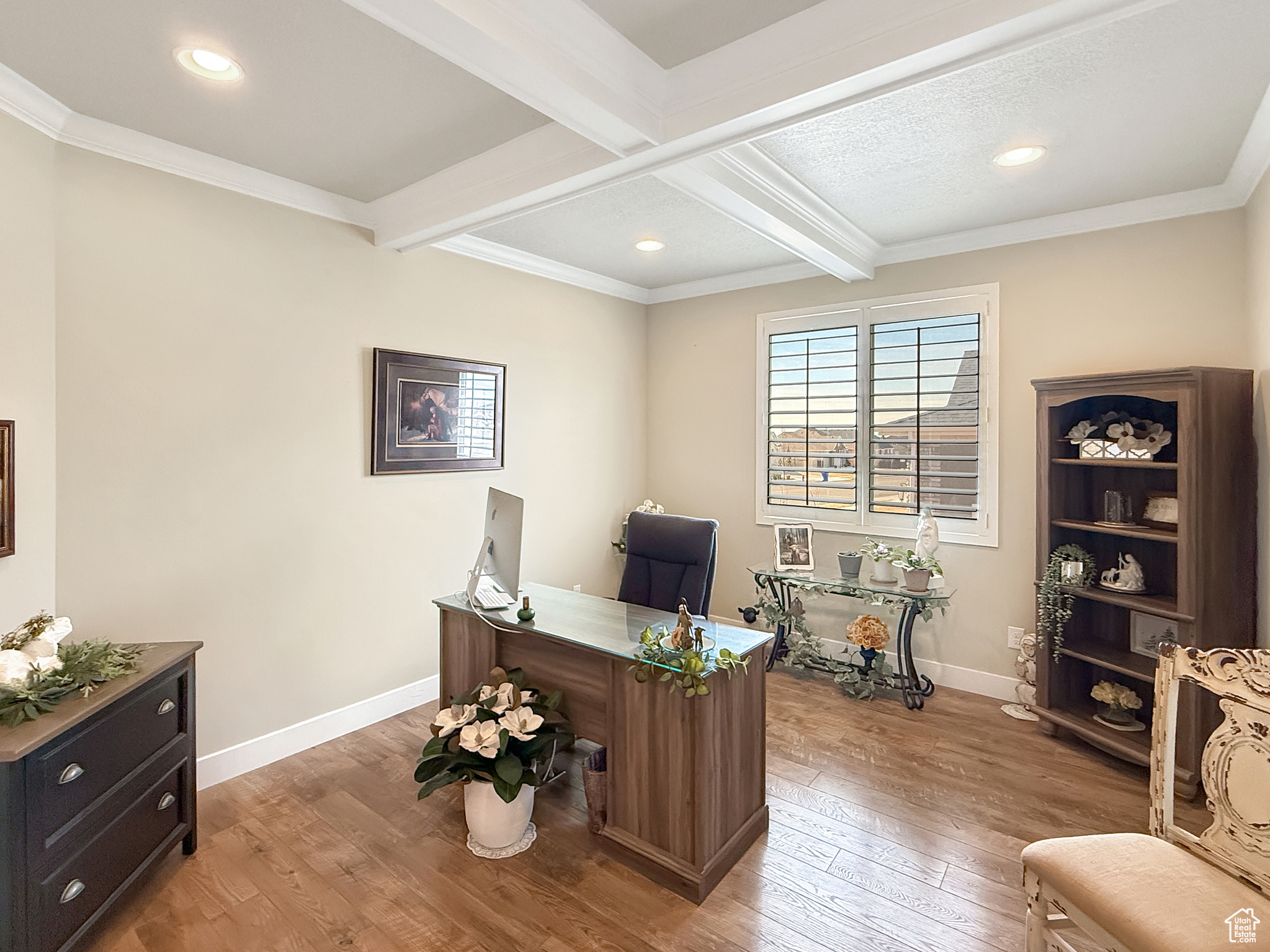 Office area with beam ceiling, crown molding, light wood-style flooring, and baseboards