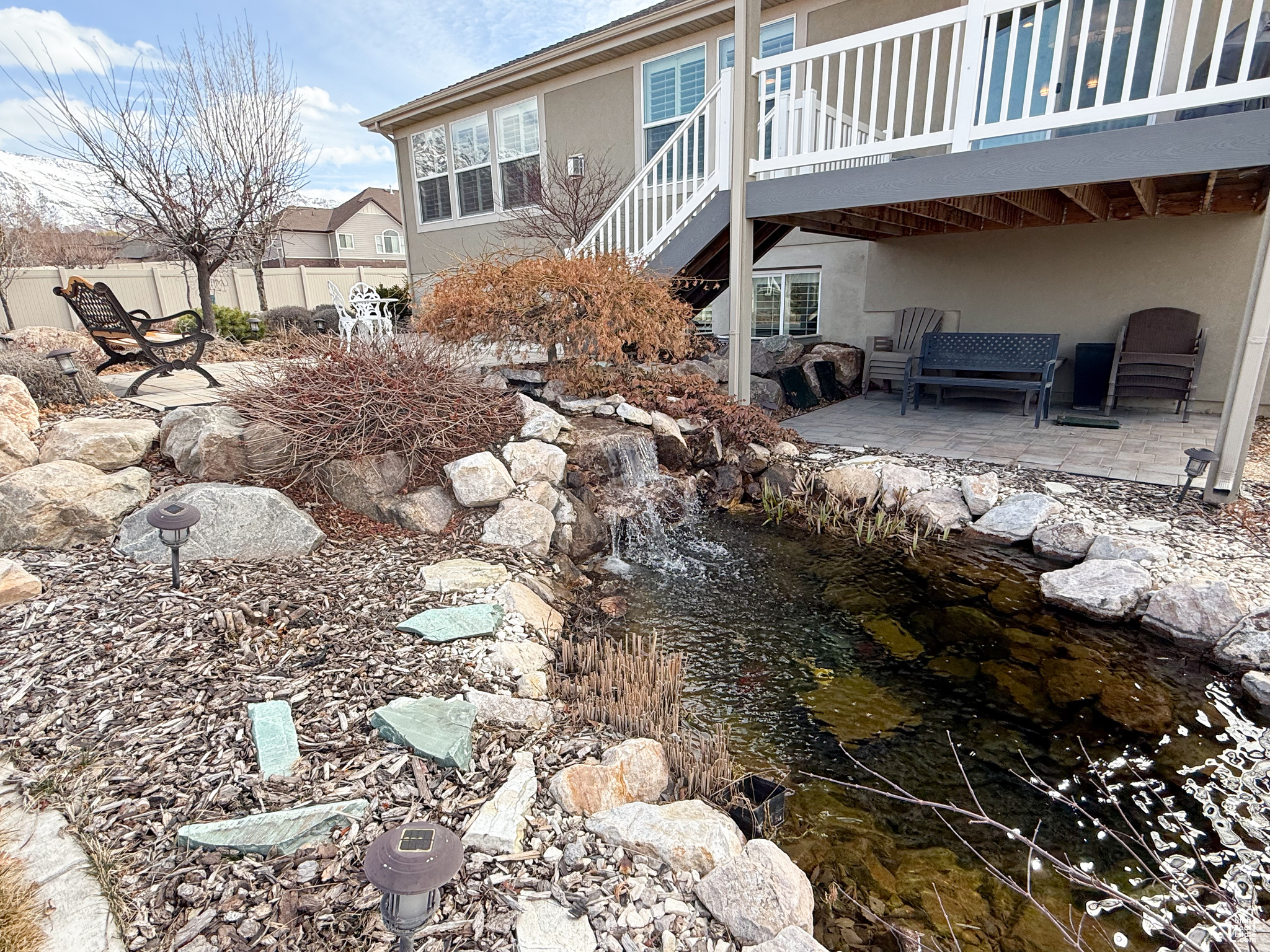 Exterior space with a patio, stucco siding, stairway, fence, and a deck