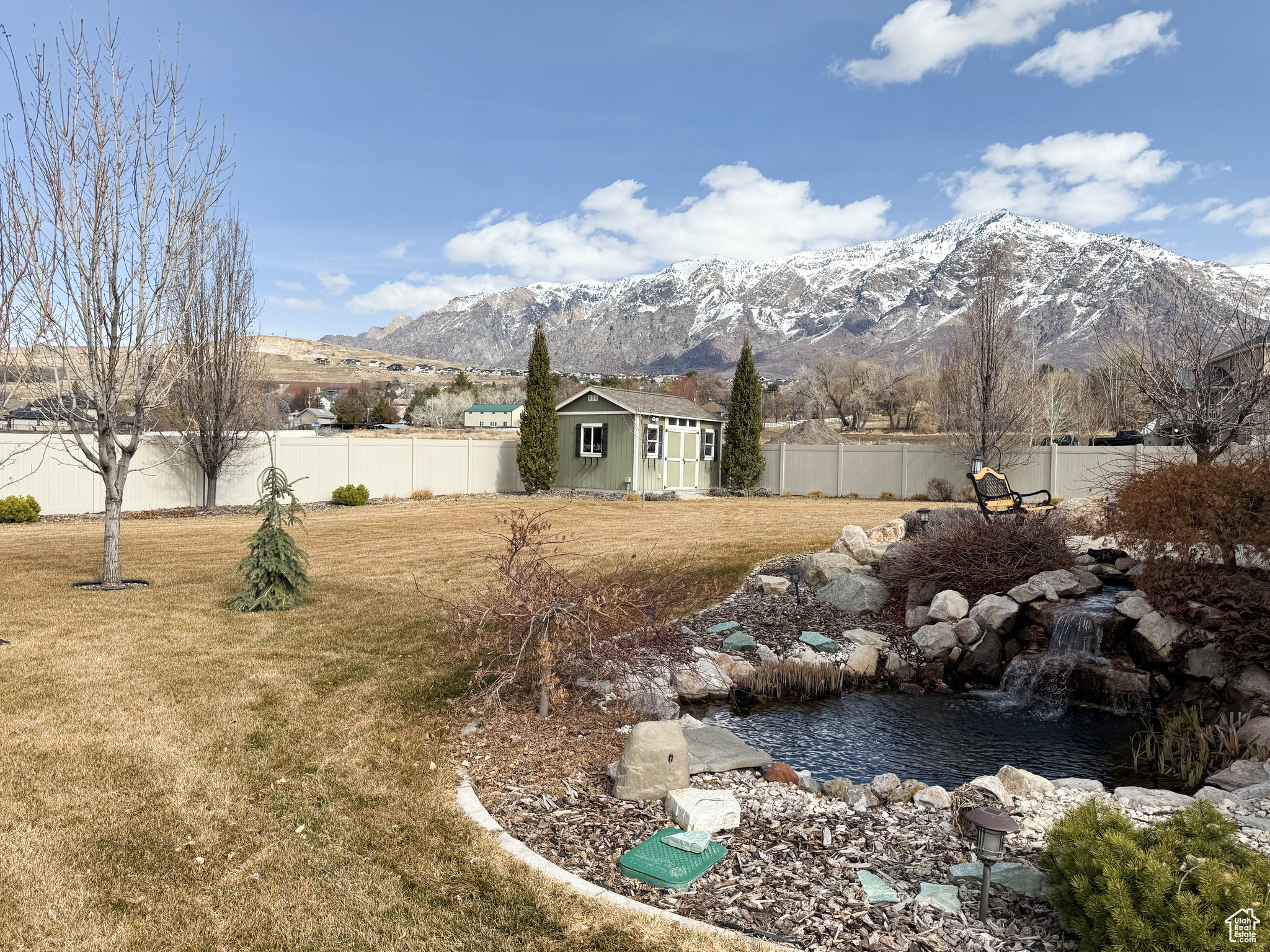 View of yard featuring an outbuilding, a fenced backyard, and a mountain view