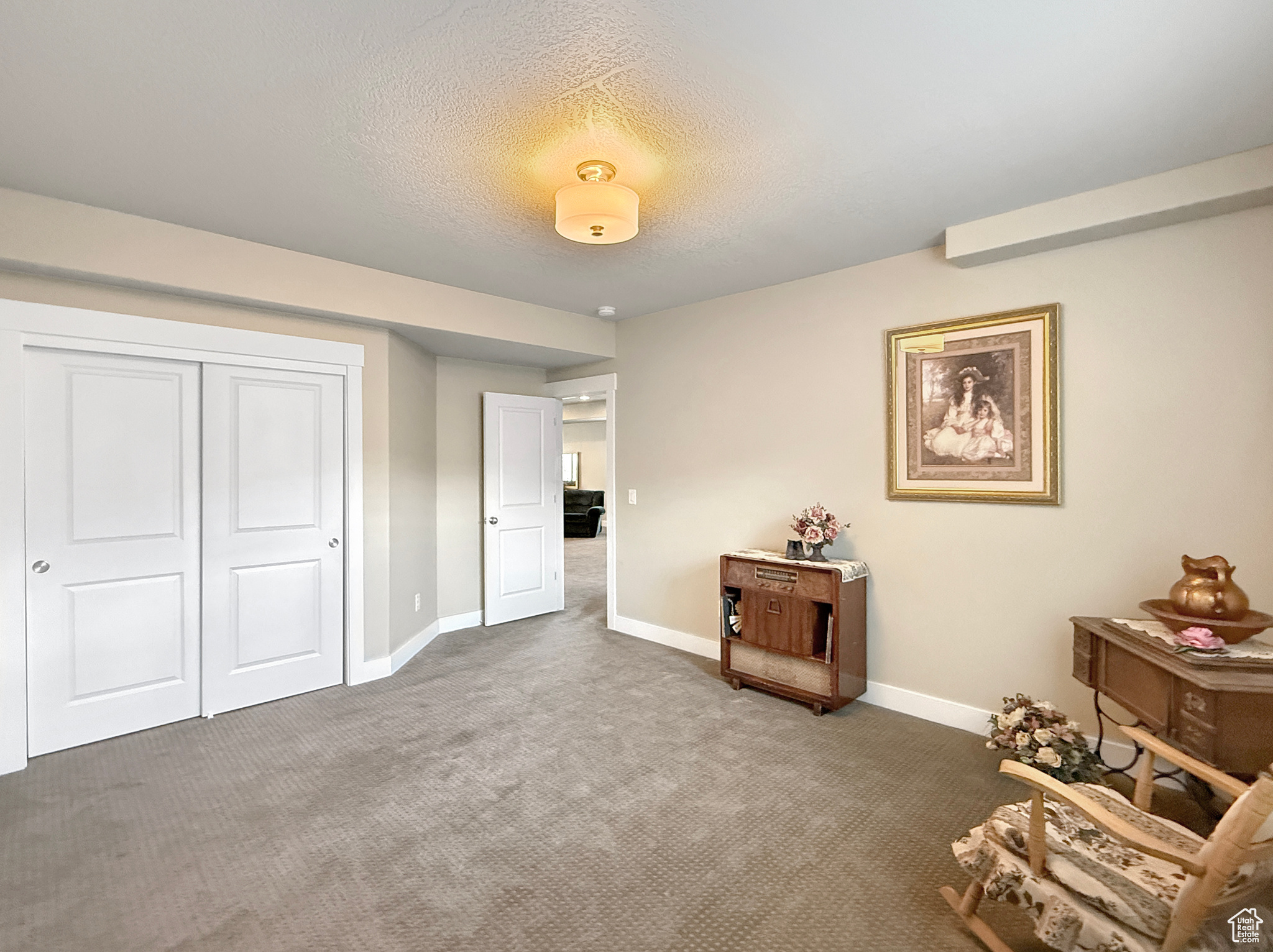 Unfurnished room featuring carpet, a textured ceiling, and baseboards