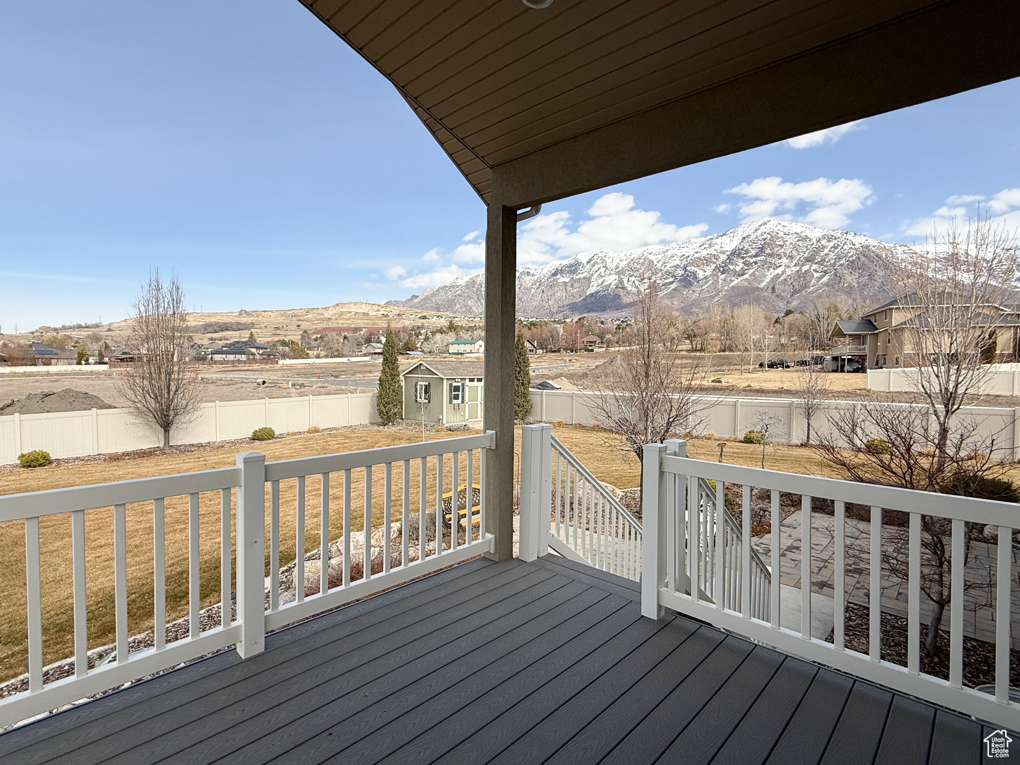 Wooden deck featuring an outbuilding, a fenced backyard, a mountain view, and a storage unit