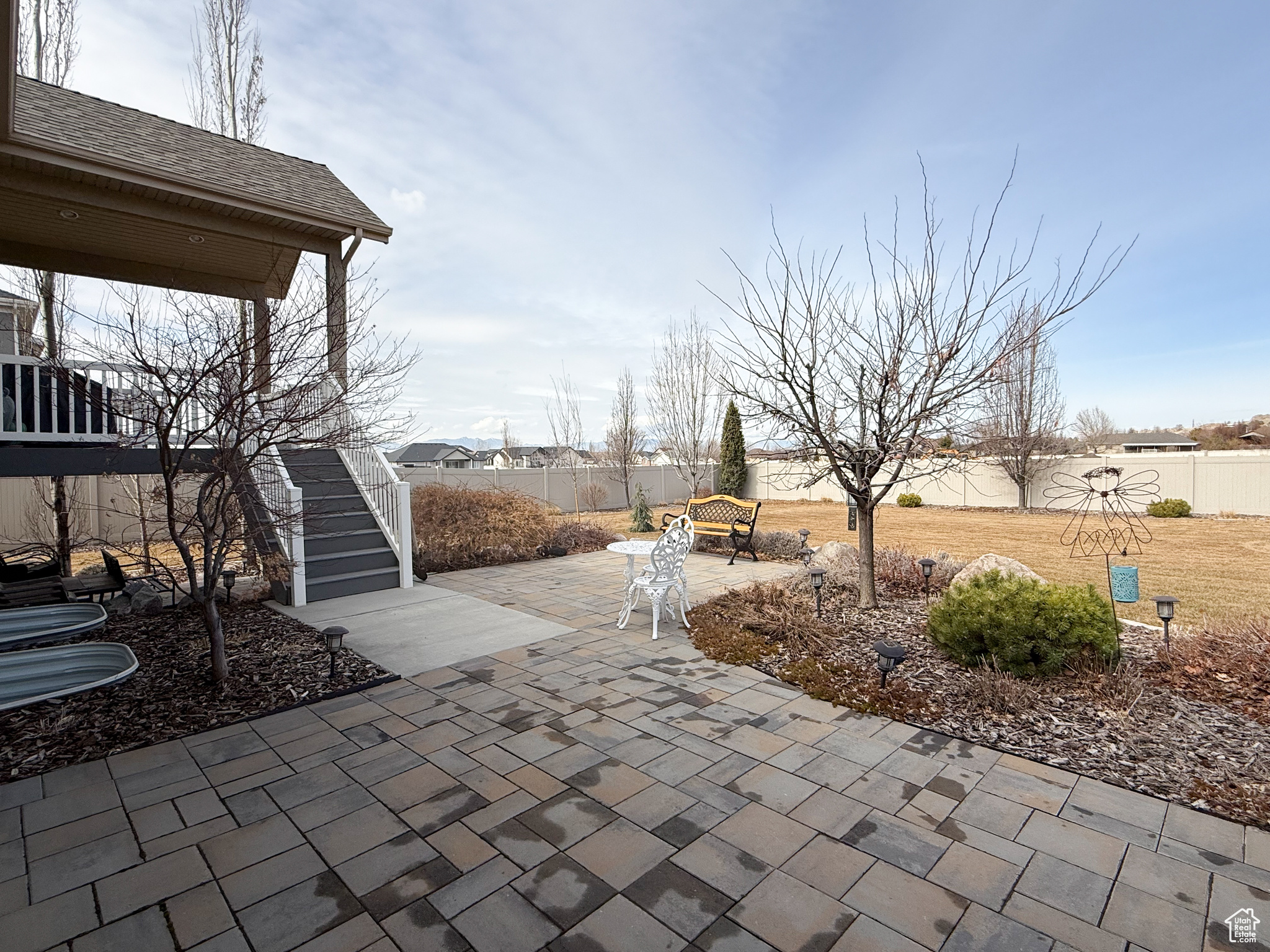 View of patio with a fenced backyard and stairway