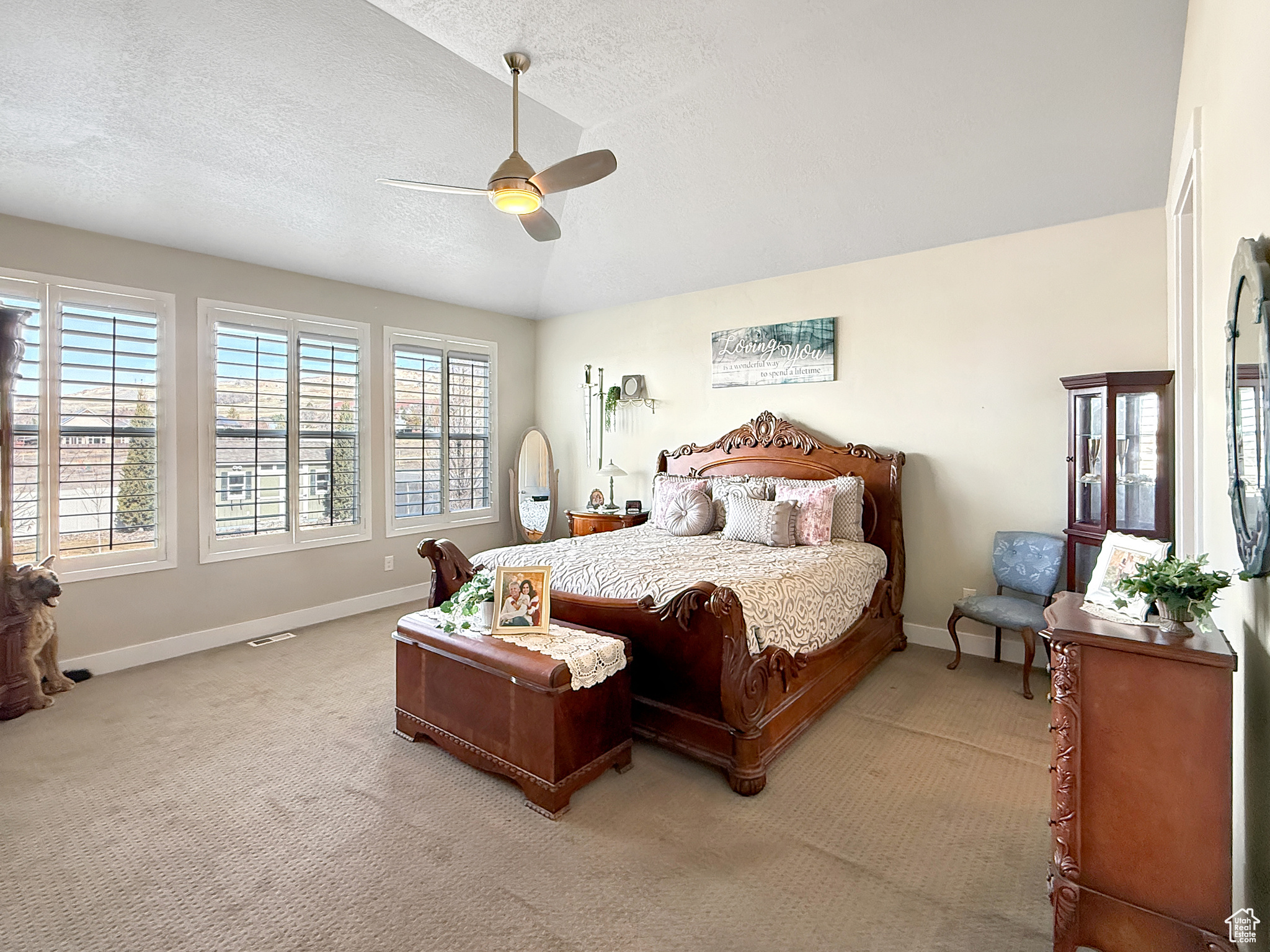 Bedroom featuring visible vents, baseboards, light colored carpet, ceiling fan, and a textured ceiling