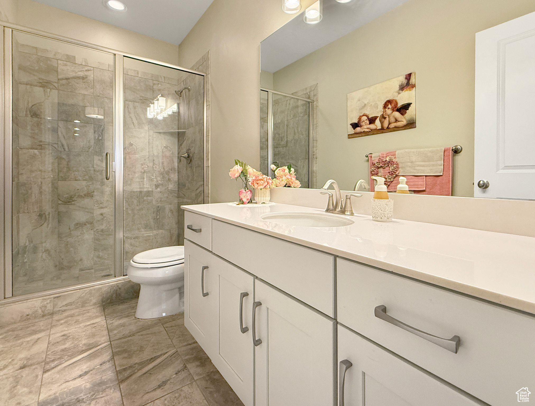 Bathroom featuring toilet, a stall shower, and vanity