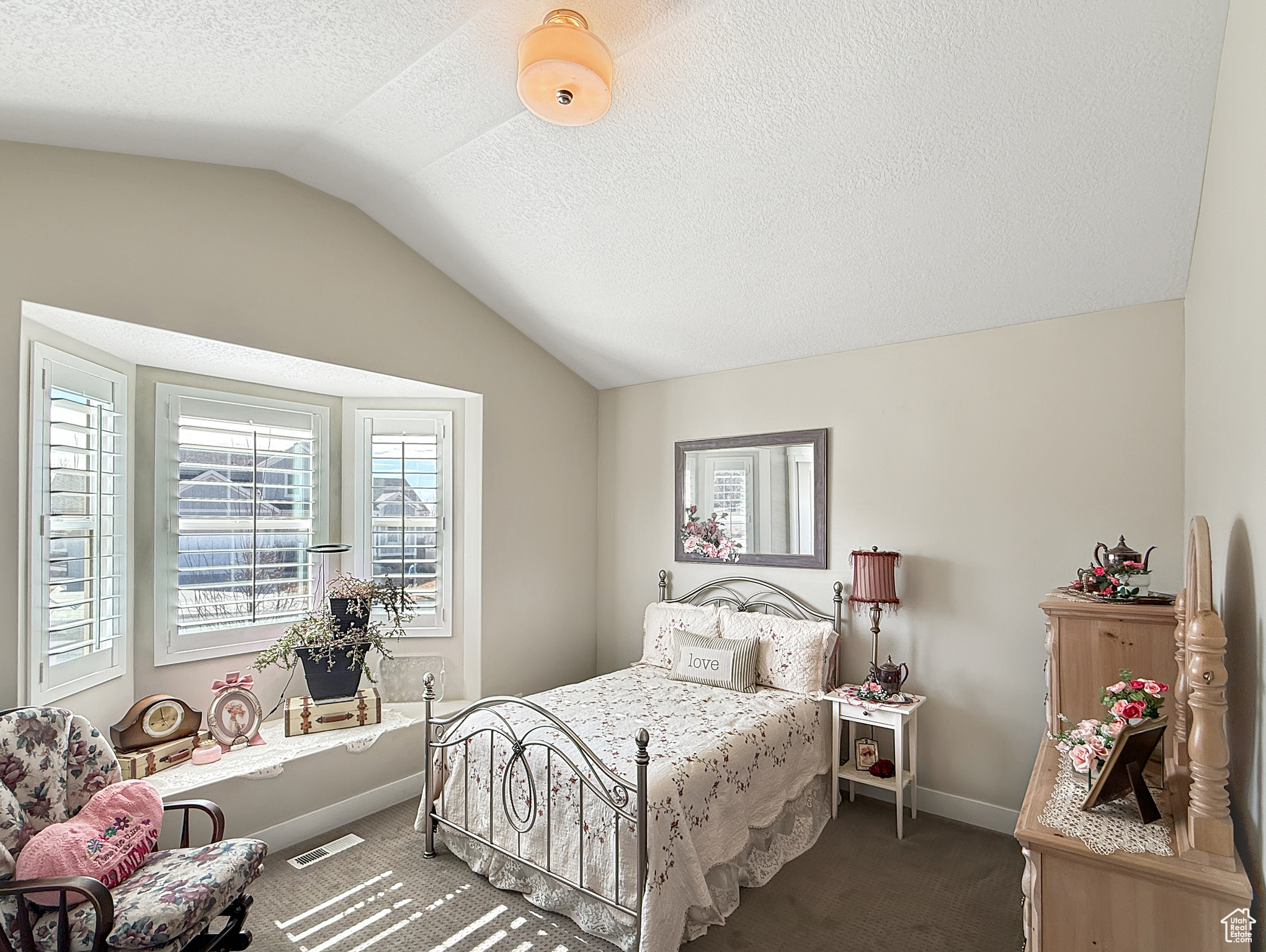 Bedroom with carpet, visible vents, lofted ceiling, and baseboards