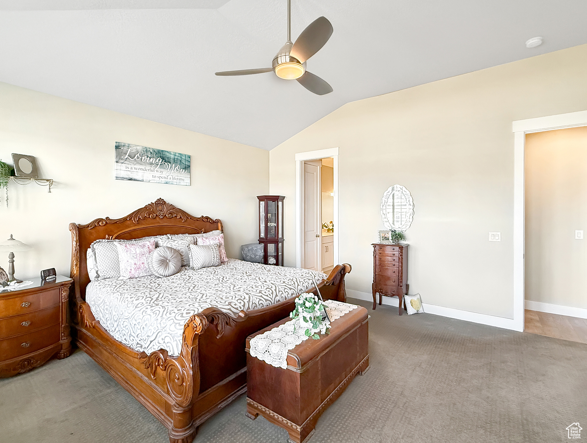 Bedroom with carpet floors, lofted ceiling, ceiling fan, connected bathroom, and baseboards