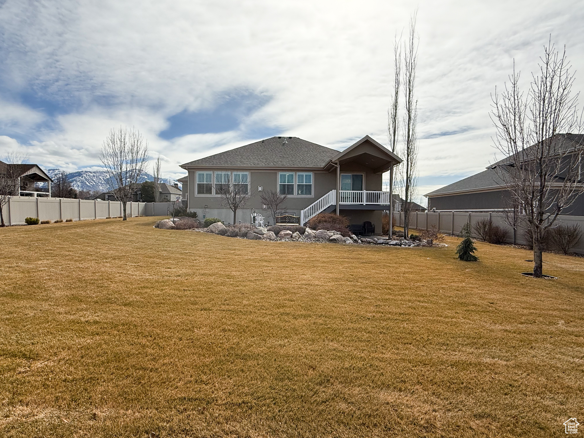 Back of house with fence and a lawn