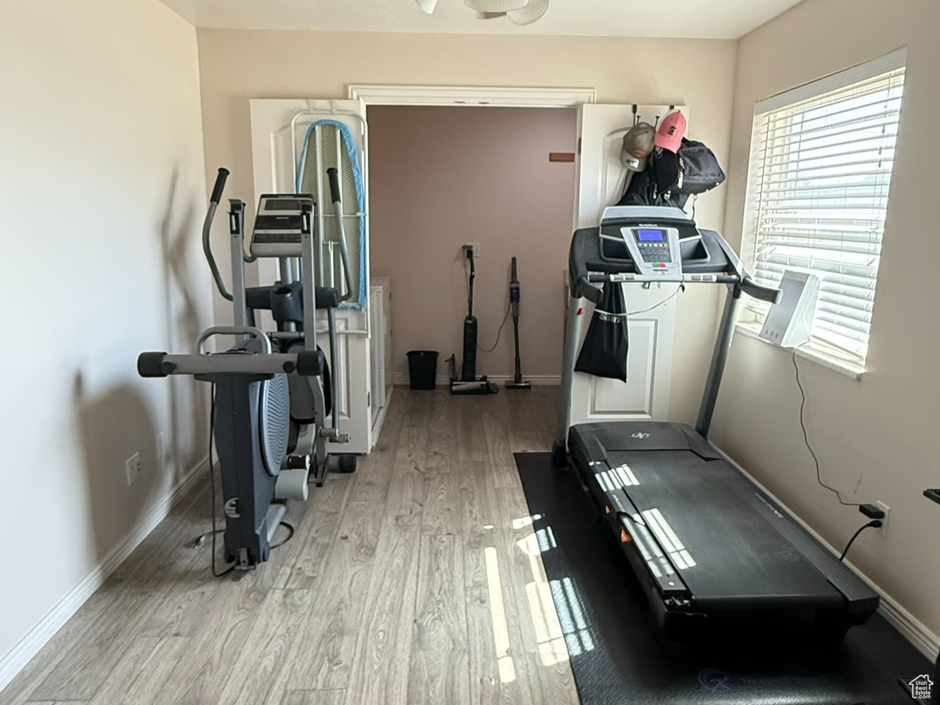 Workout room with a textured ceiling, baseboards, and wood finished floors