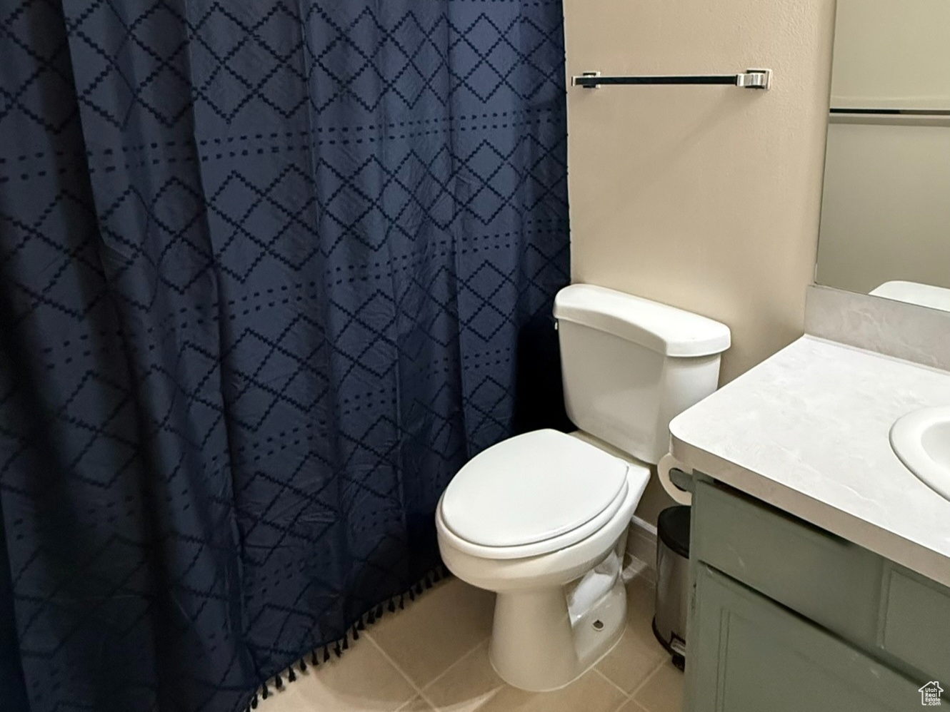 Full bathroom featuring toilet, curtained shower, vanity, and tile patterned floors