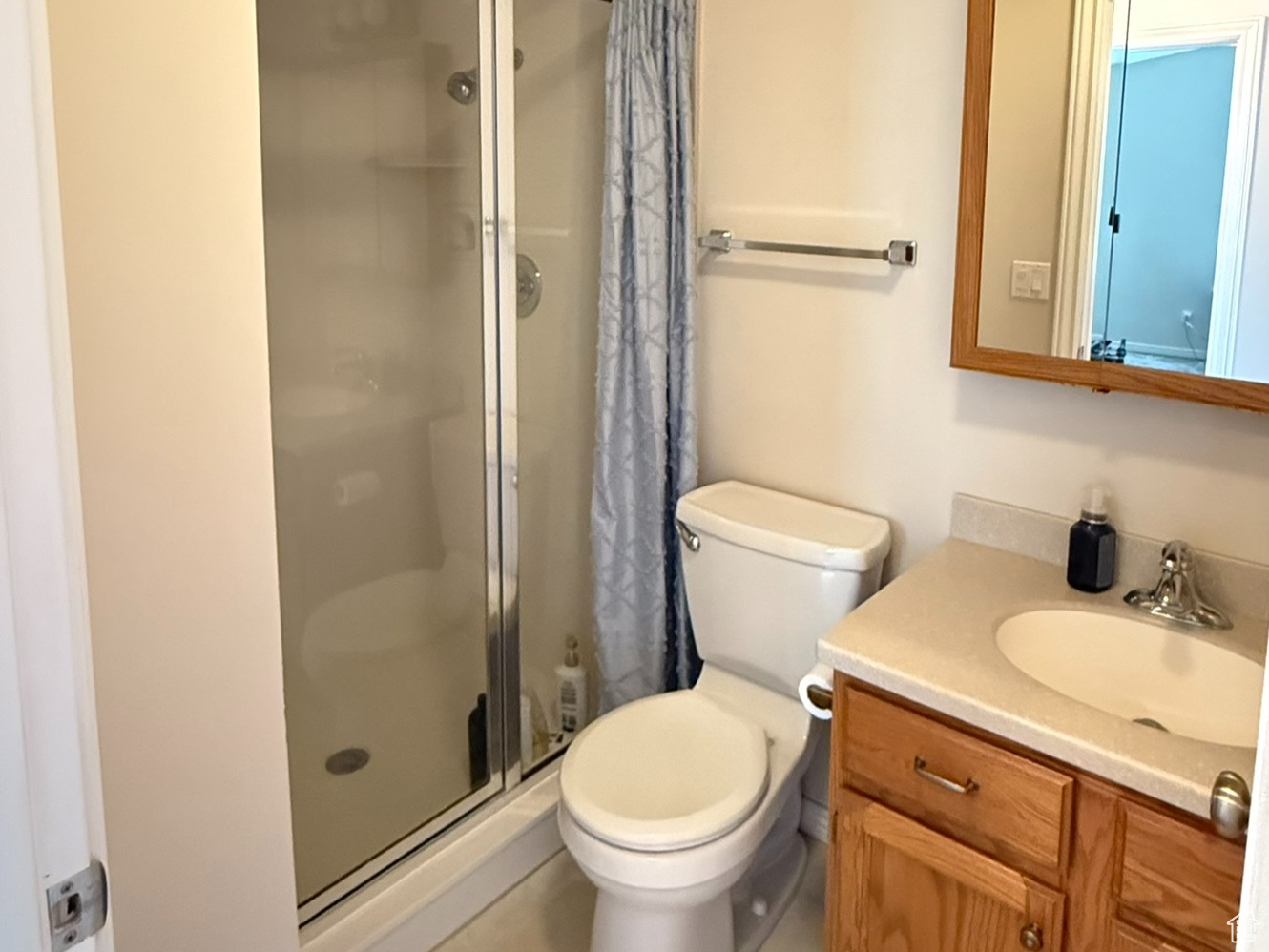 Bathroom with toilet, a shower stall, and vanity