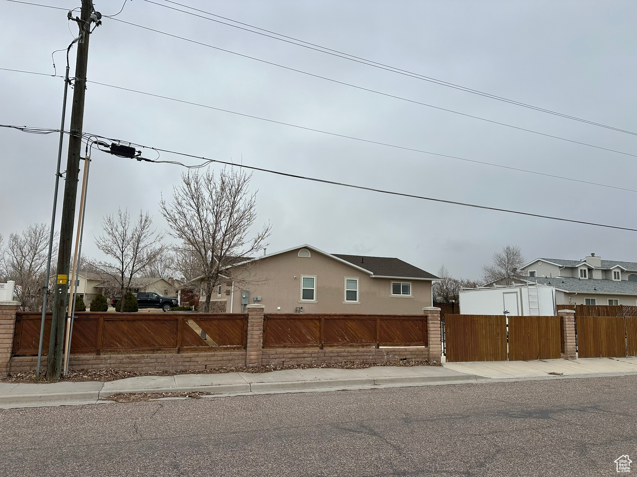 View of property exterior featuring a fenced front yard, a gate, and stucco siding