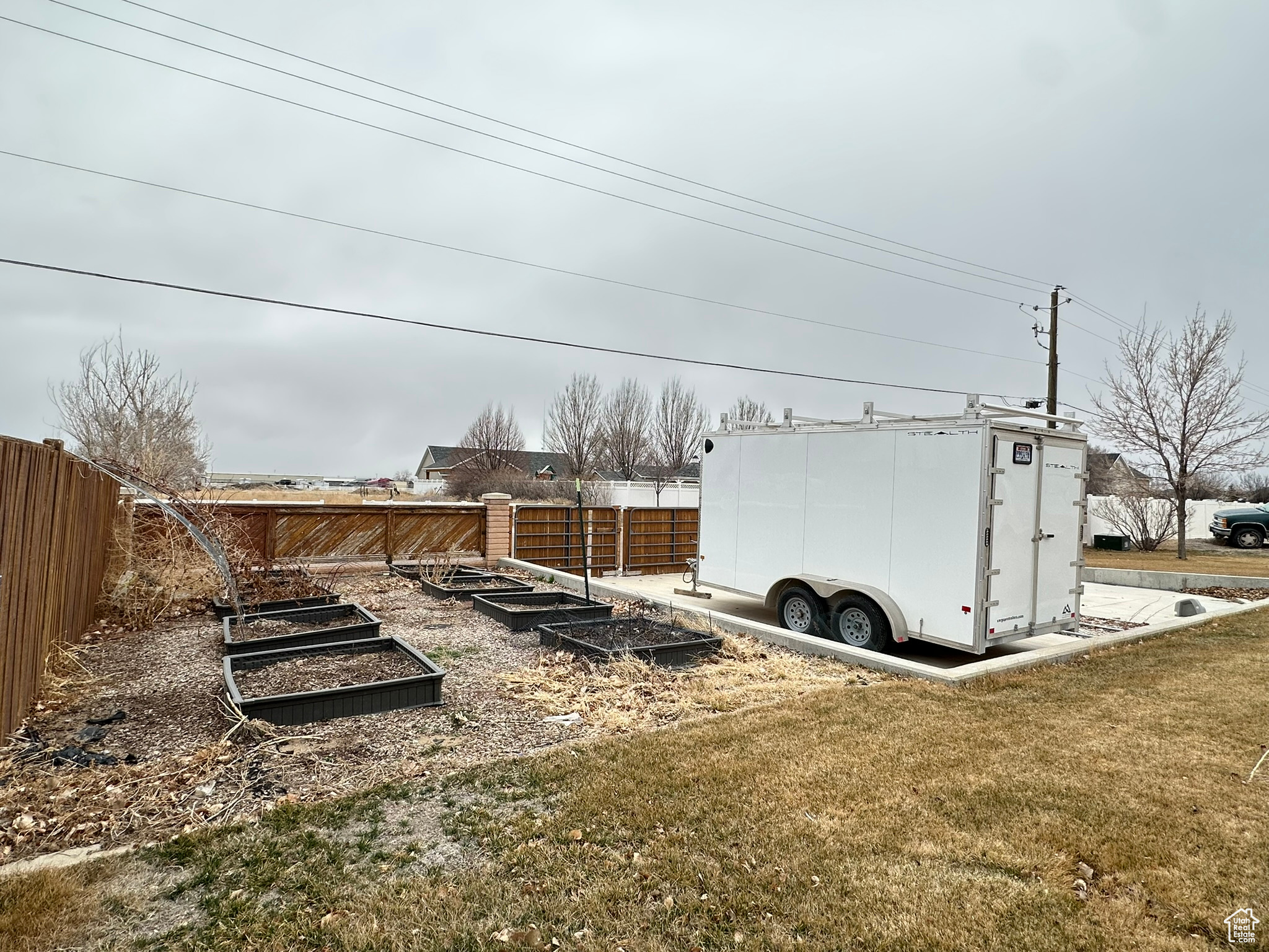 View of yard featuring fence and a garden