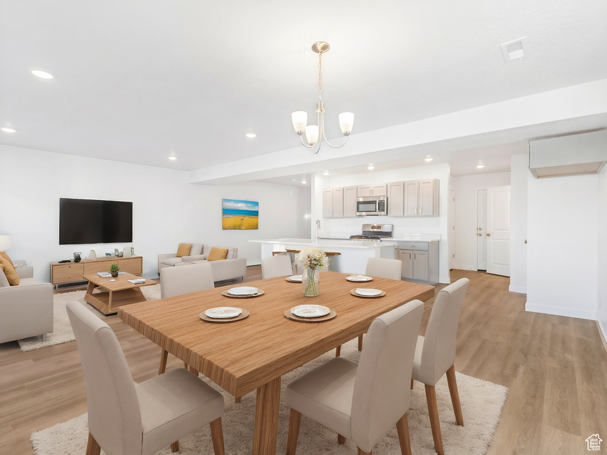 Dining space featuring light wood-type flooring, baseboards, a chandelier, and recessed lighting