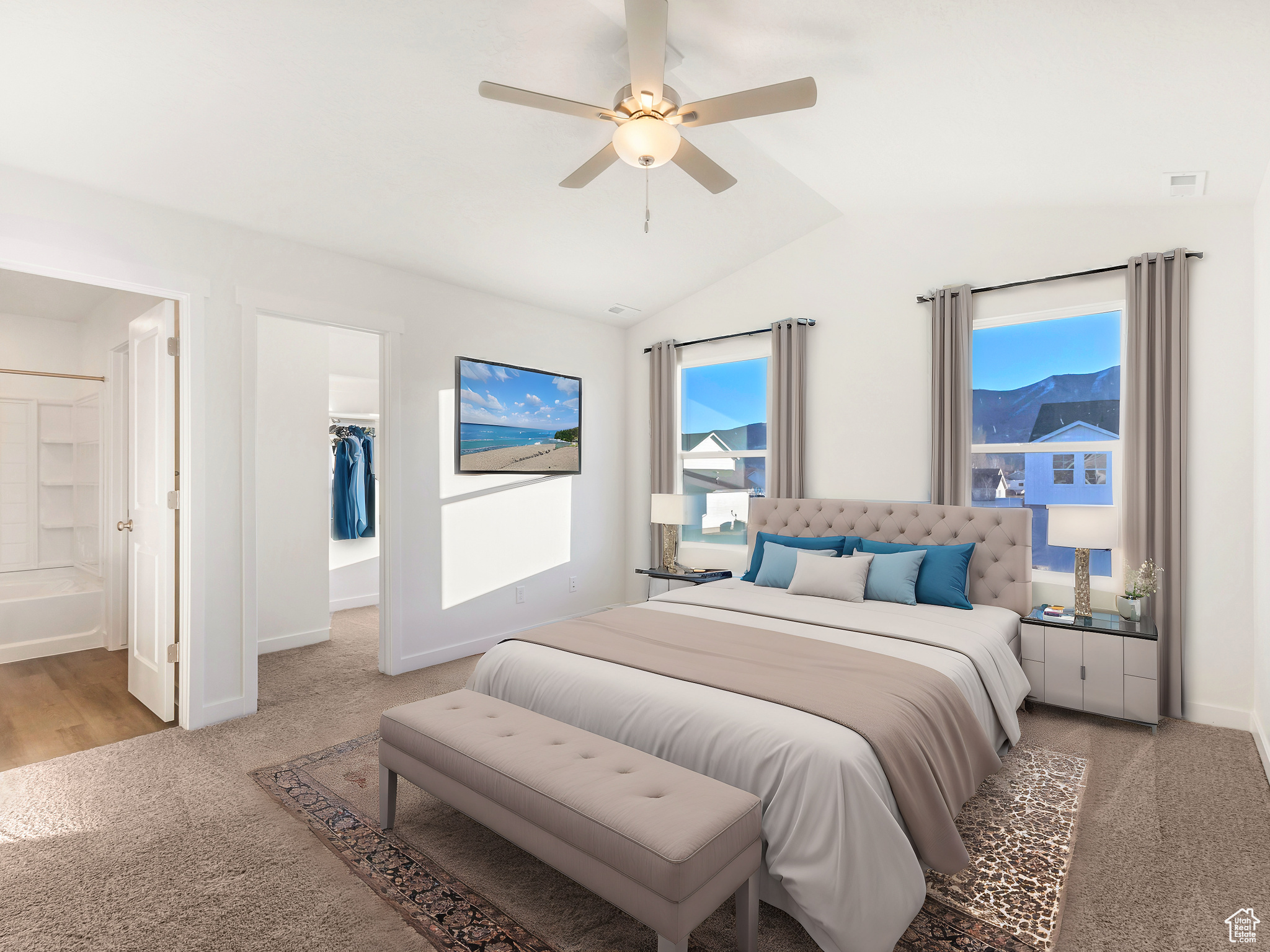 Bedroom with lofted ceiling, ceiling fan, connected bathroom, light carpet, and a spacious closet