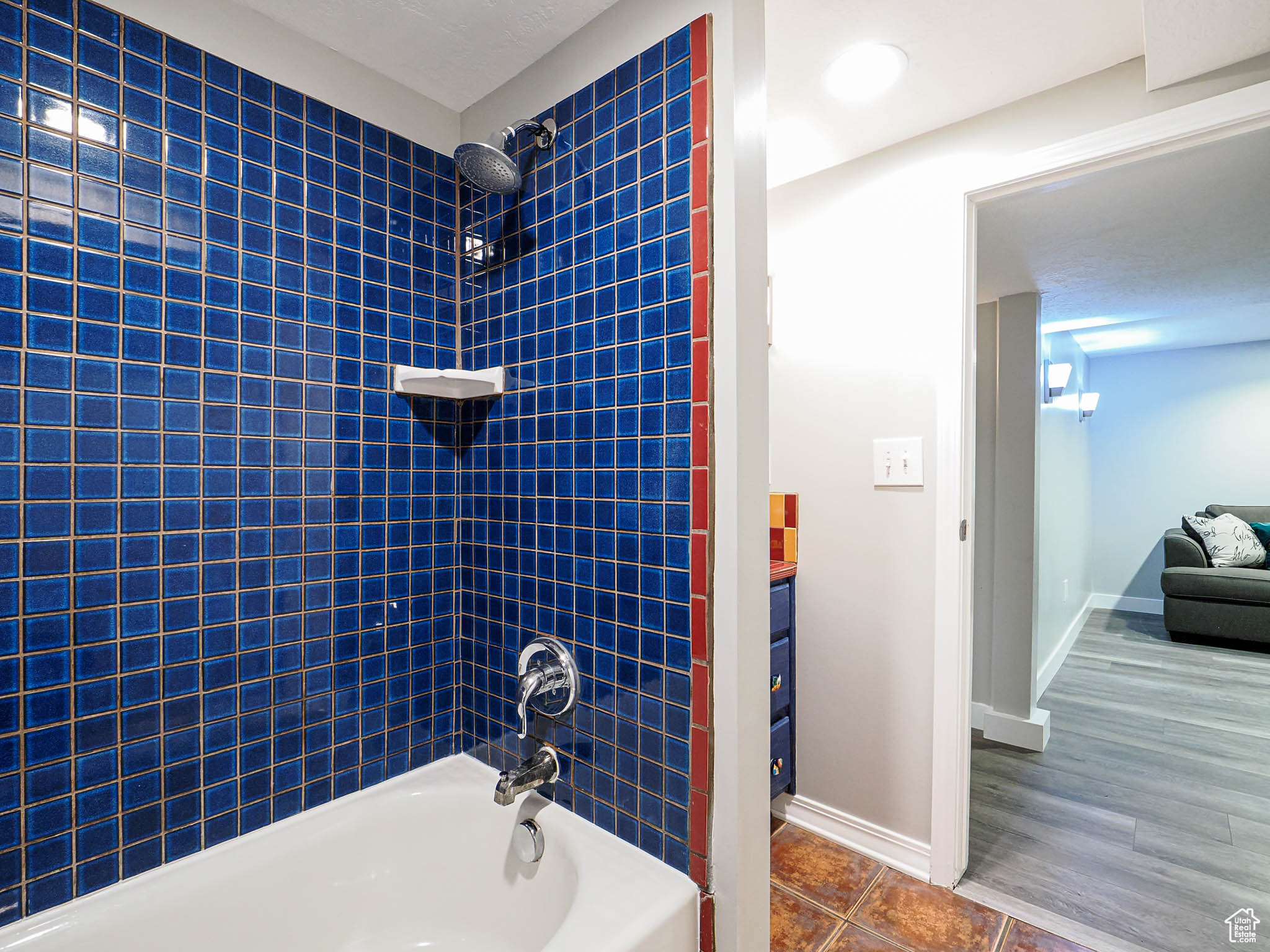 Bathroom featuring tub / shower combination, tile patterned flooring, and baseboards