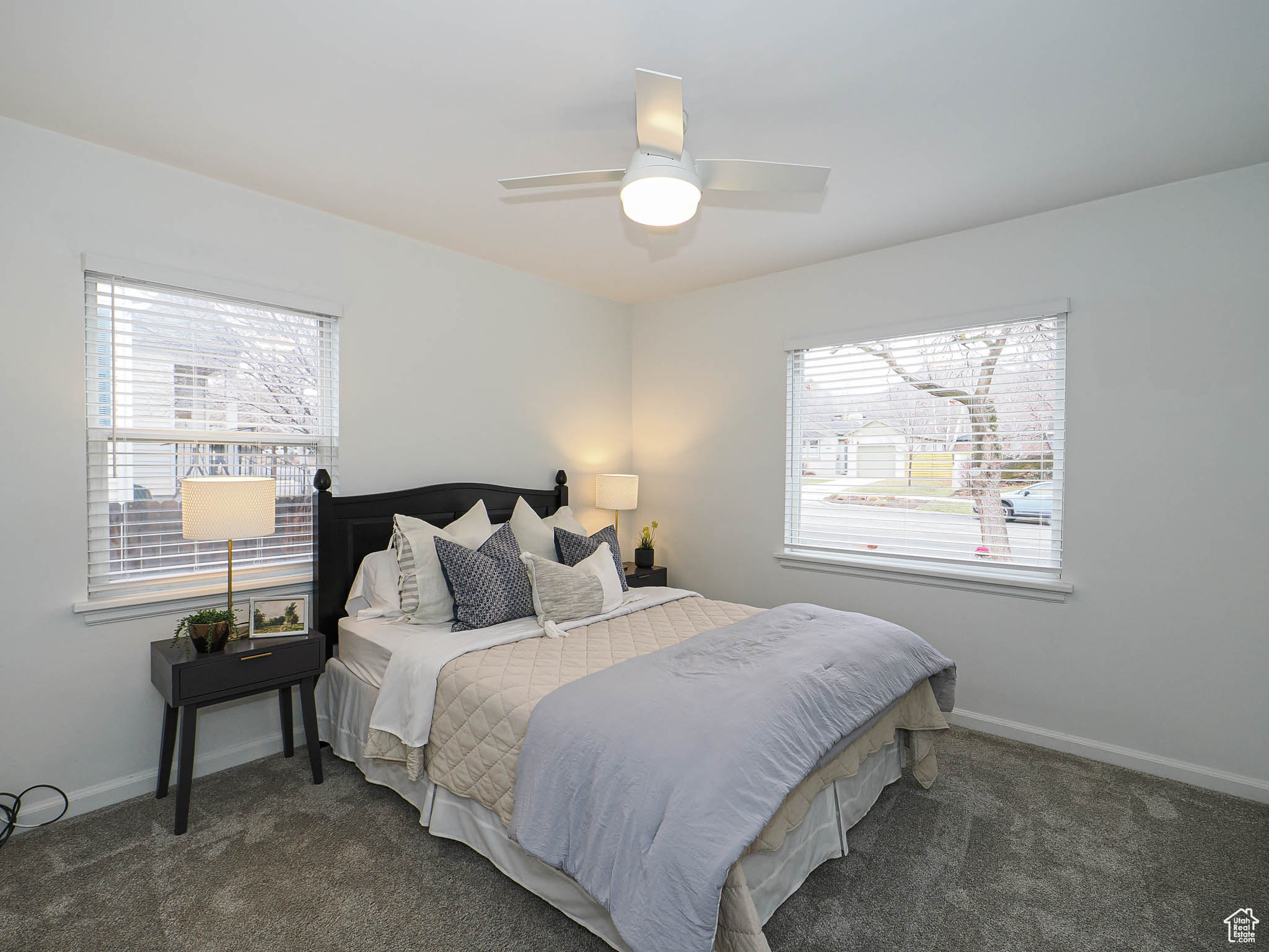 Carpeted bedroom with ceiling fan and baseboards