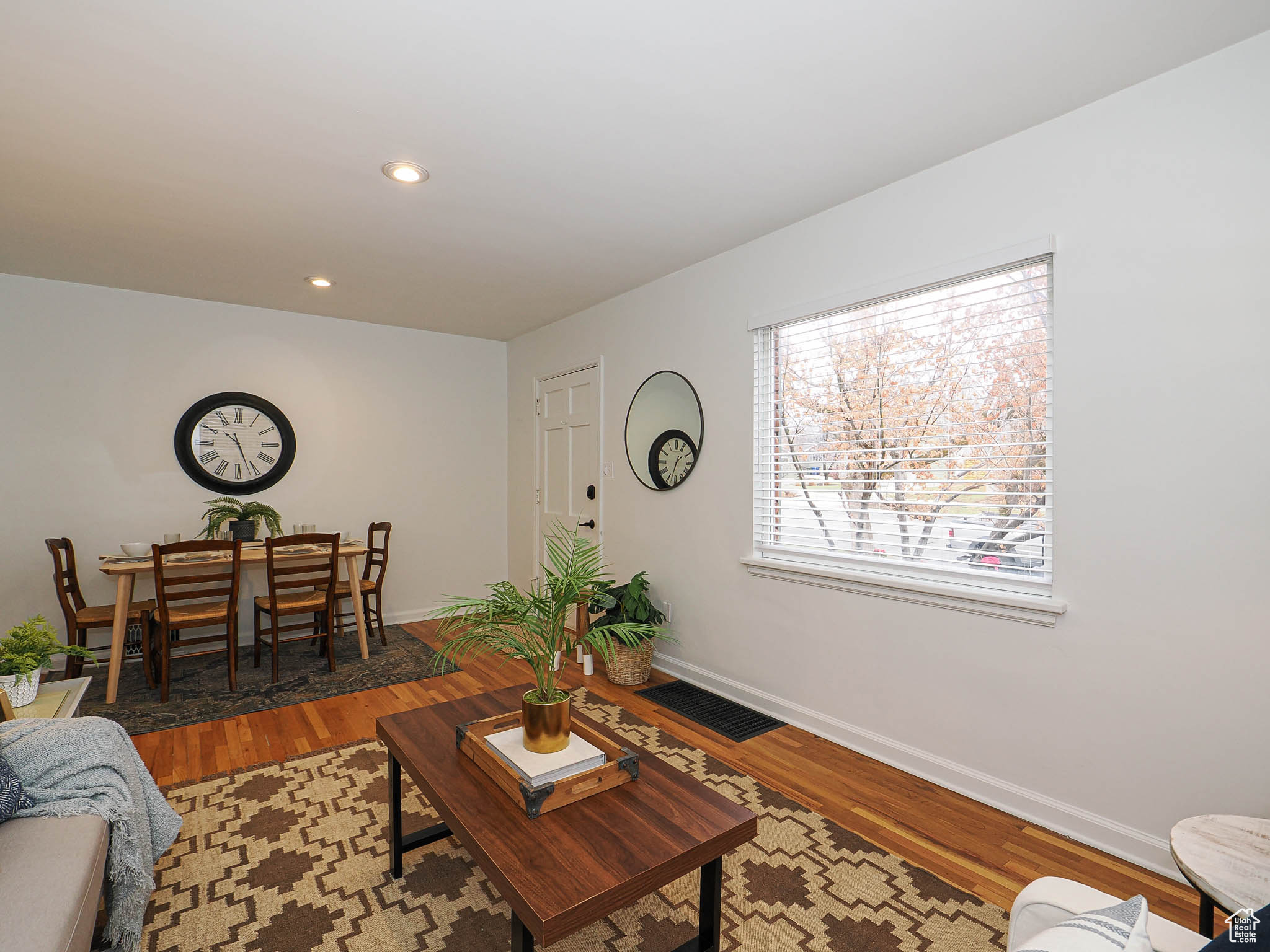 Living room with recessed lighting, visible vents, baseboards, and wood finished floors