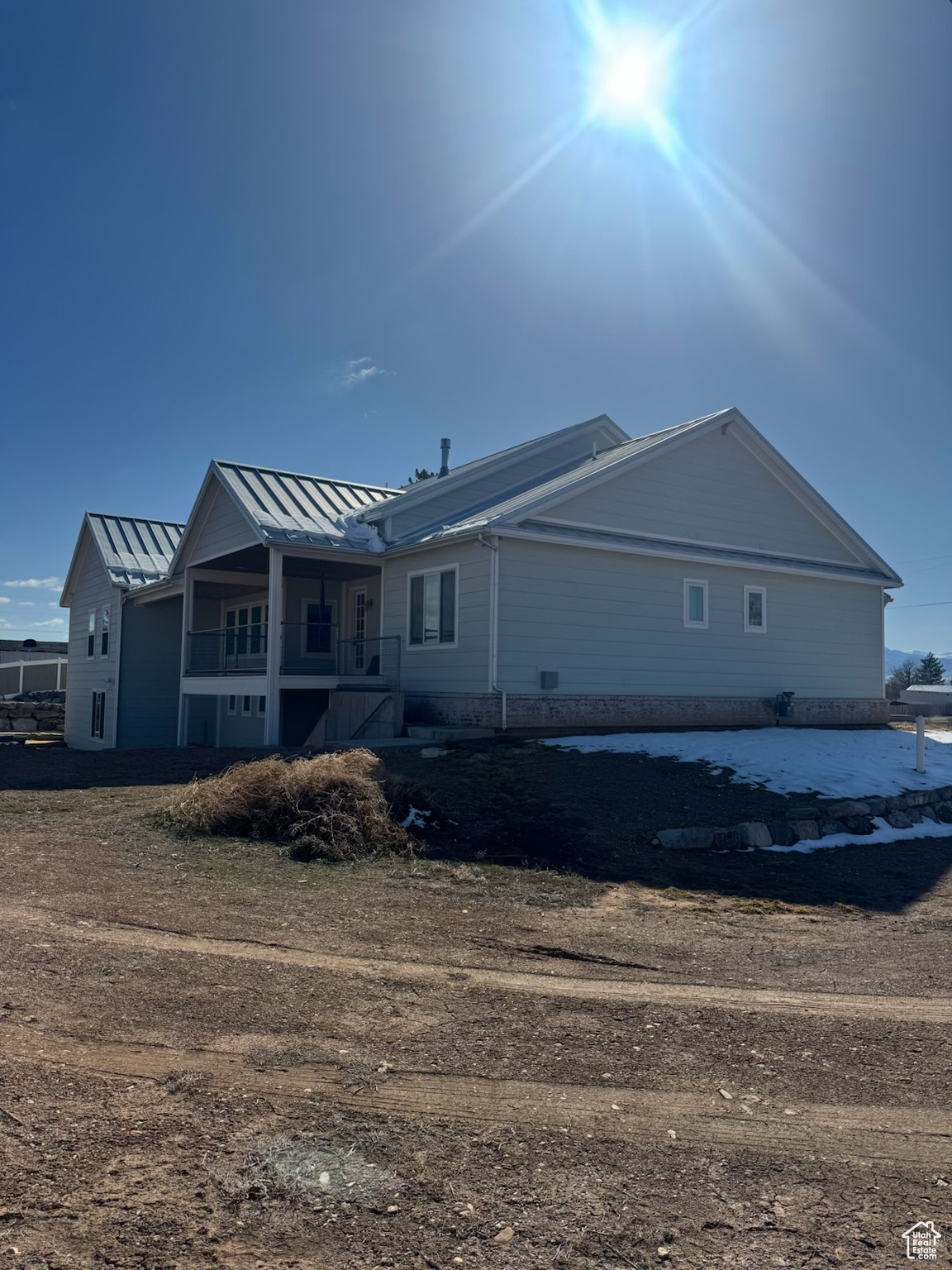 Back of property with metal roof and a standing seam roof