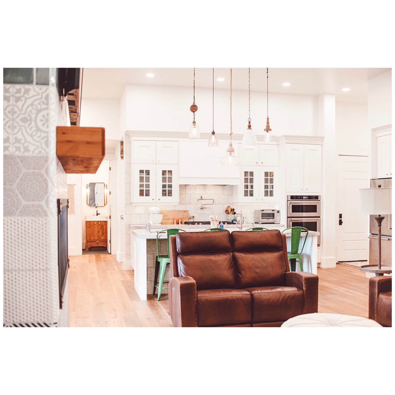 Living room with recessed lighting, light wood-type flooring, a high ceiling, and a toaster