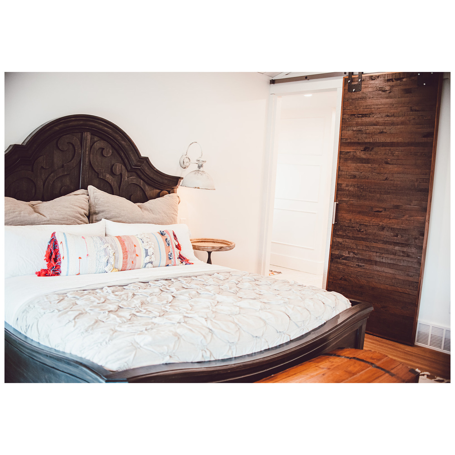 Bedroom with wood finished floors and a barn door