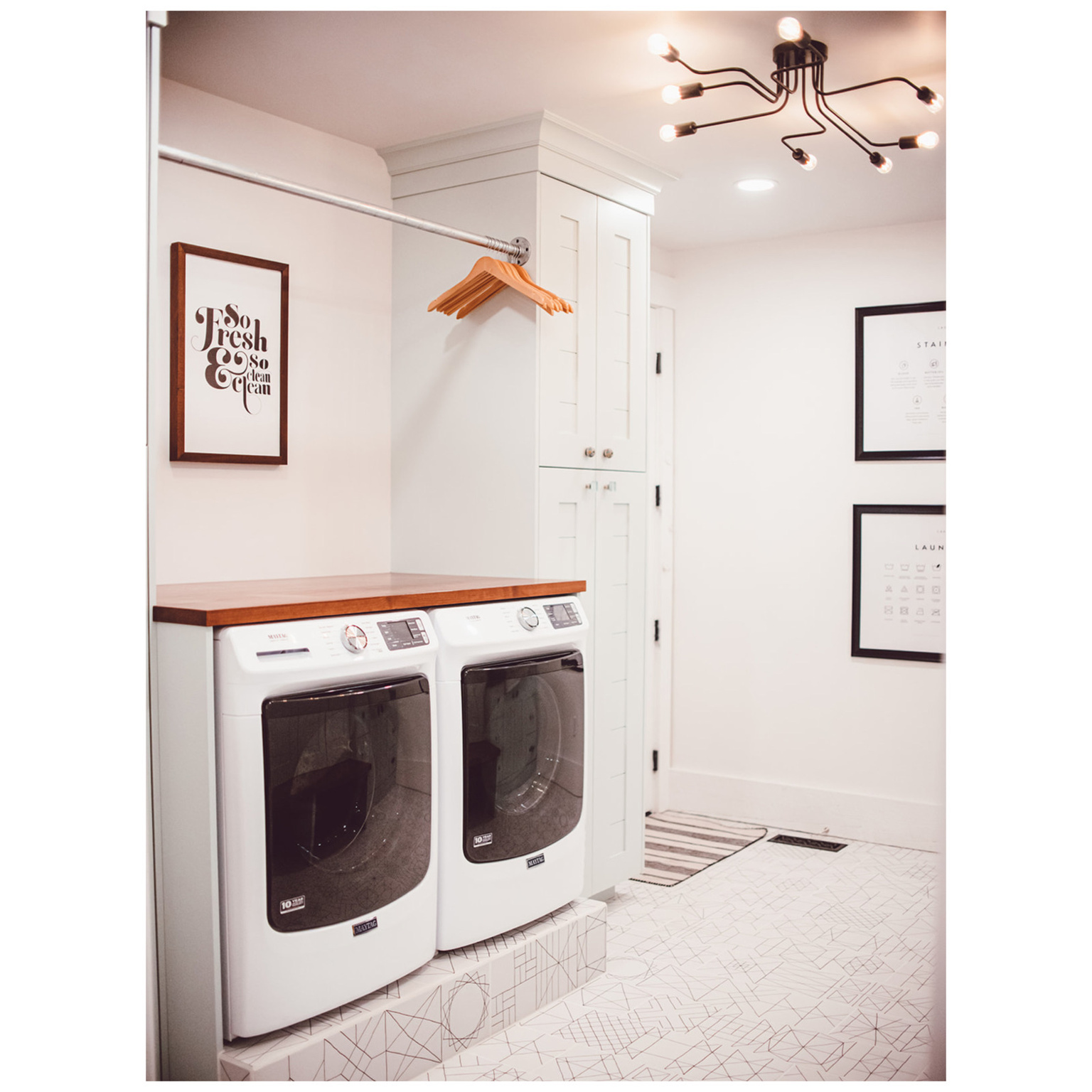 Laundry area featuring cabinet space, baseboards, a chandelier, and washer and dryer