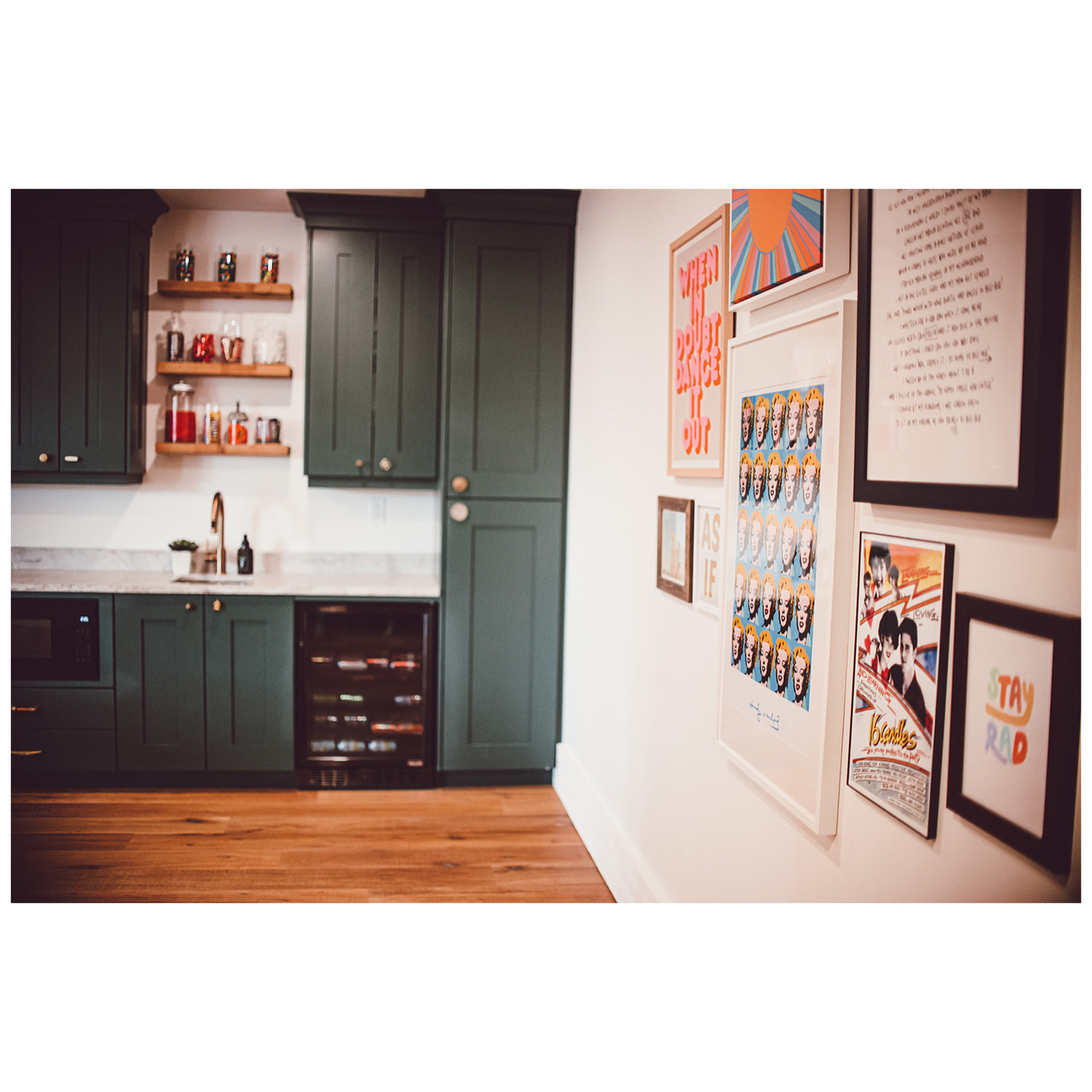 Bar with light wood-style floors, a sink, wet bar, beverage cooler, and baseboards