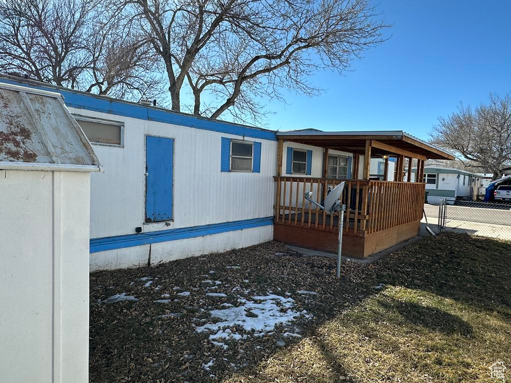 View of property exterior featuring a deck and fence