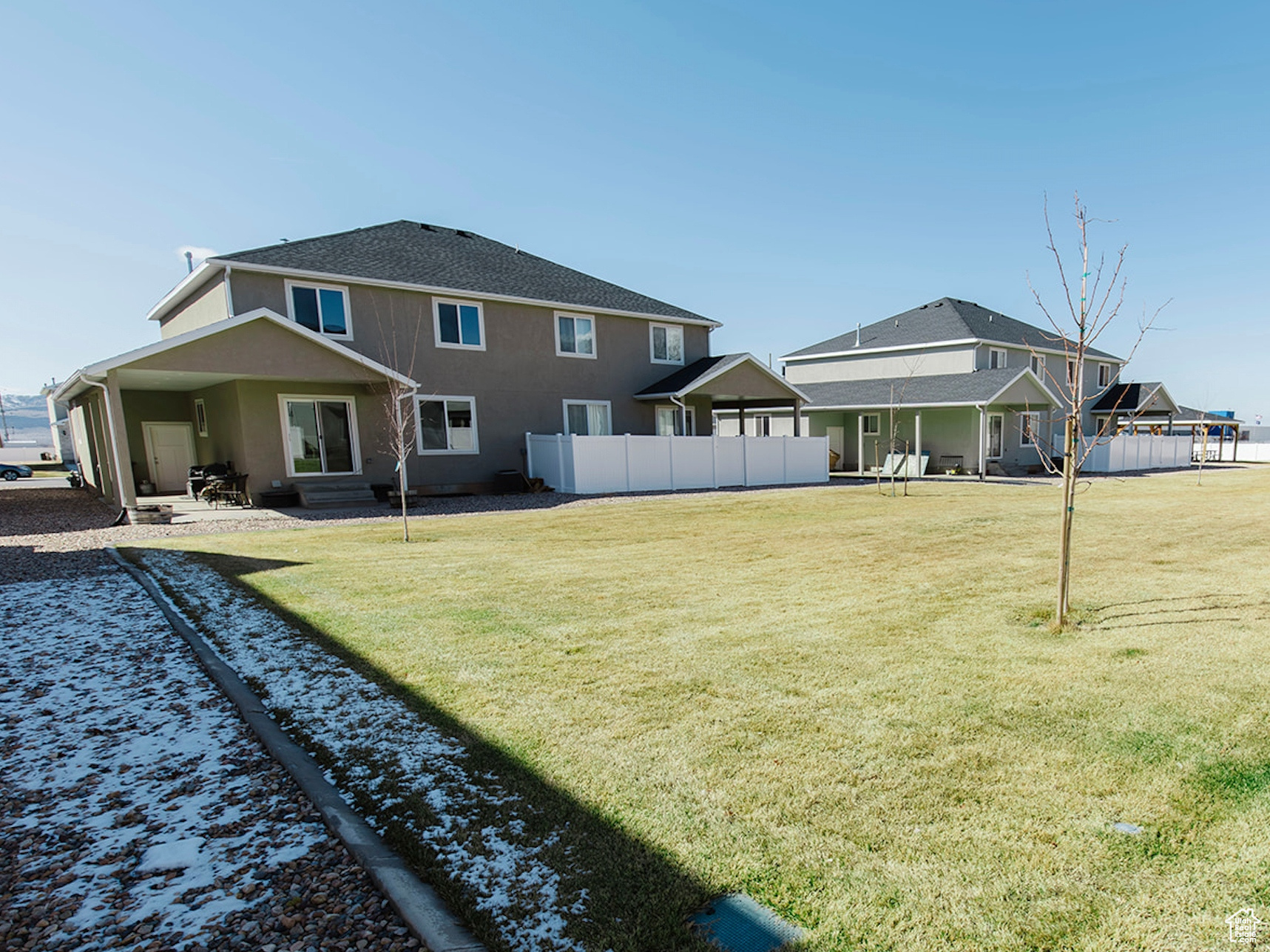 Back of property with a yard and fence