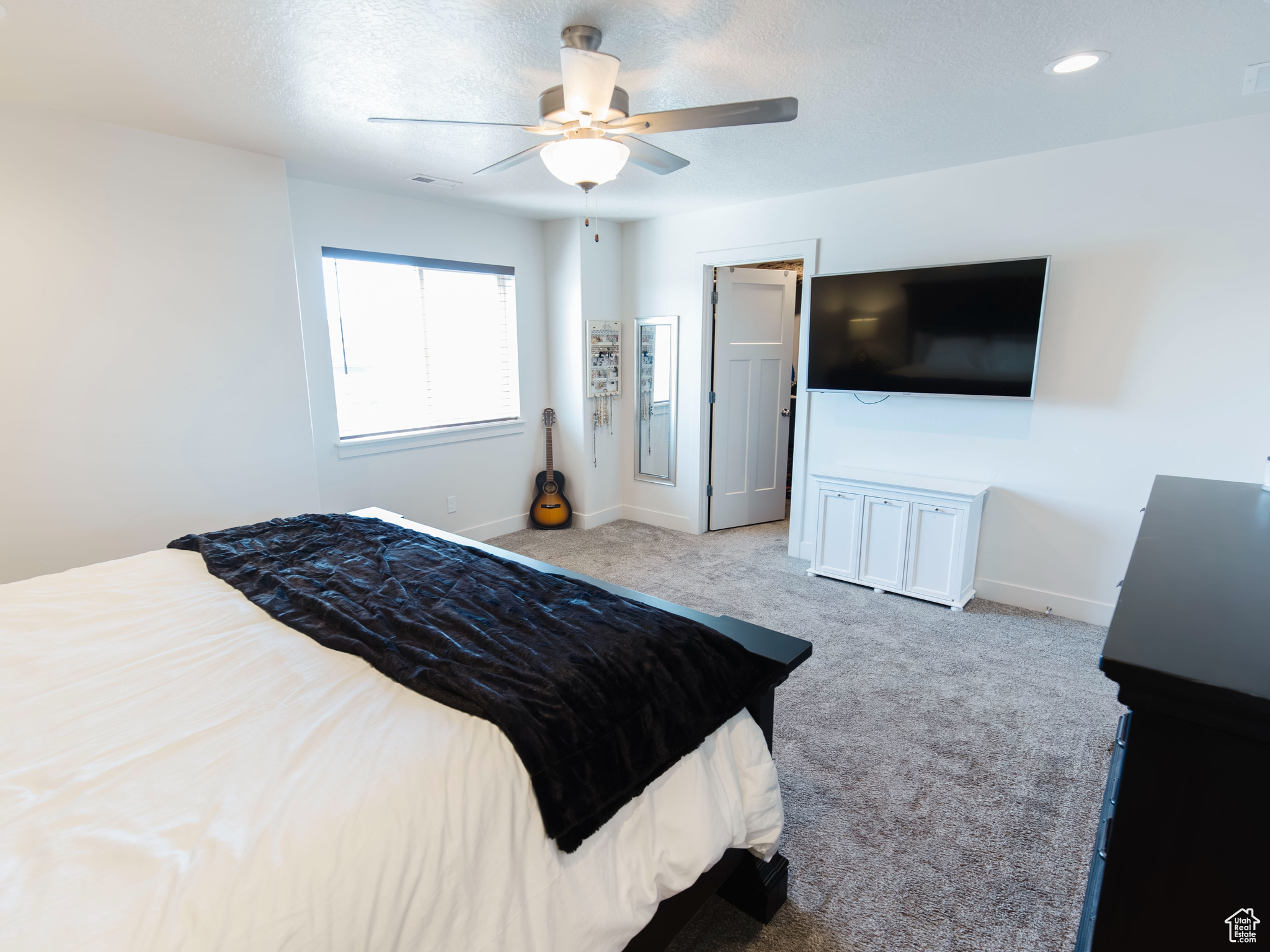 Bedroom featuring carpet flooring, ceiling fan, visible vents, and baseboards