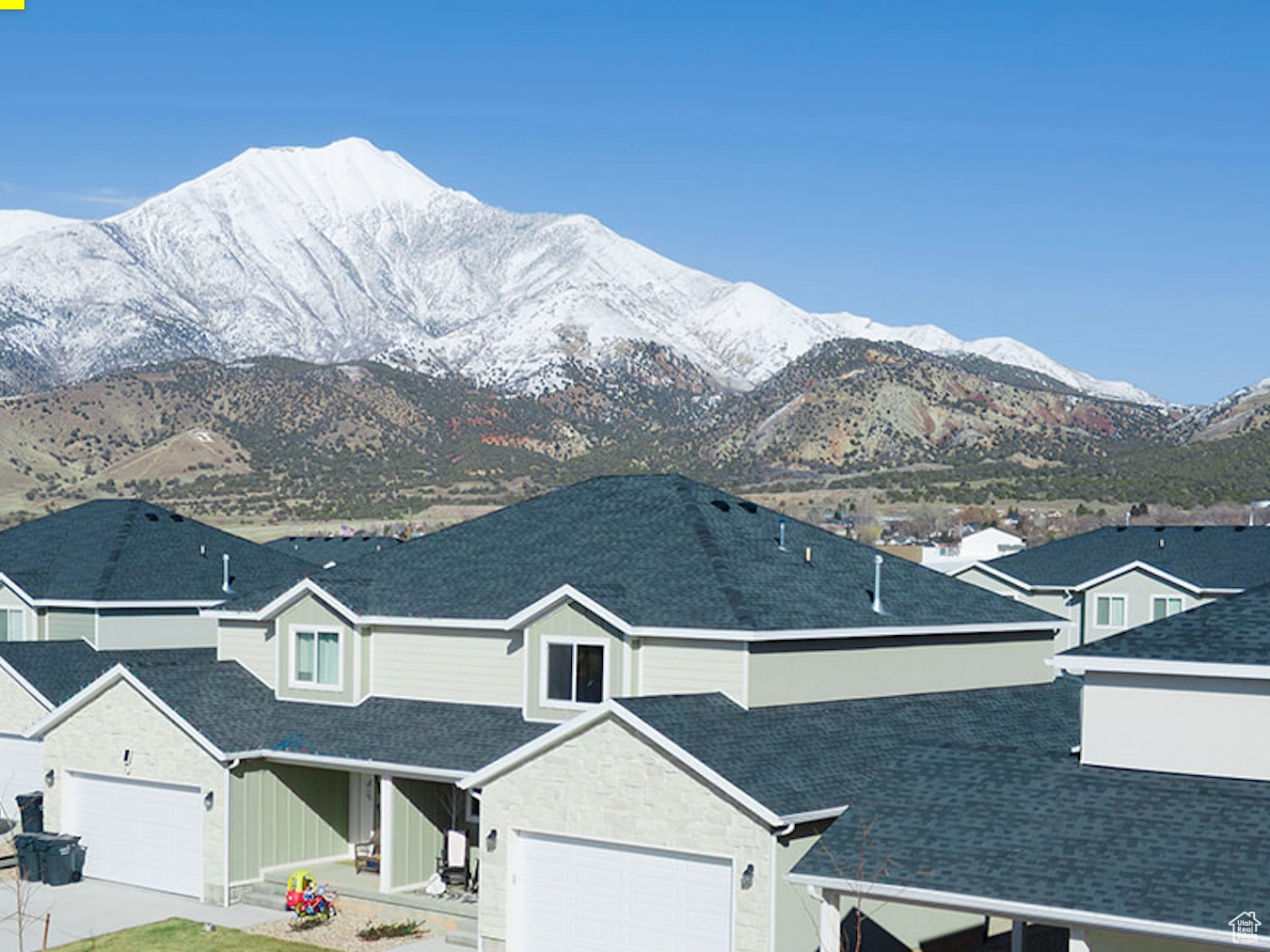 View of front of house with a mountain view, concrete driveway, and roof with shingles