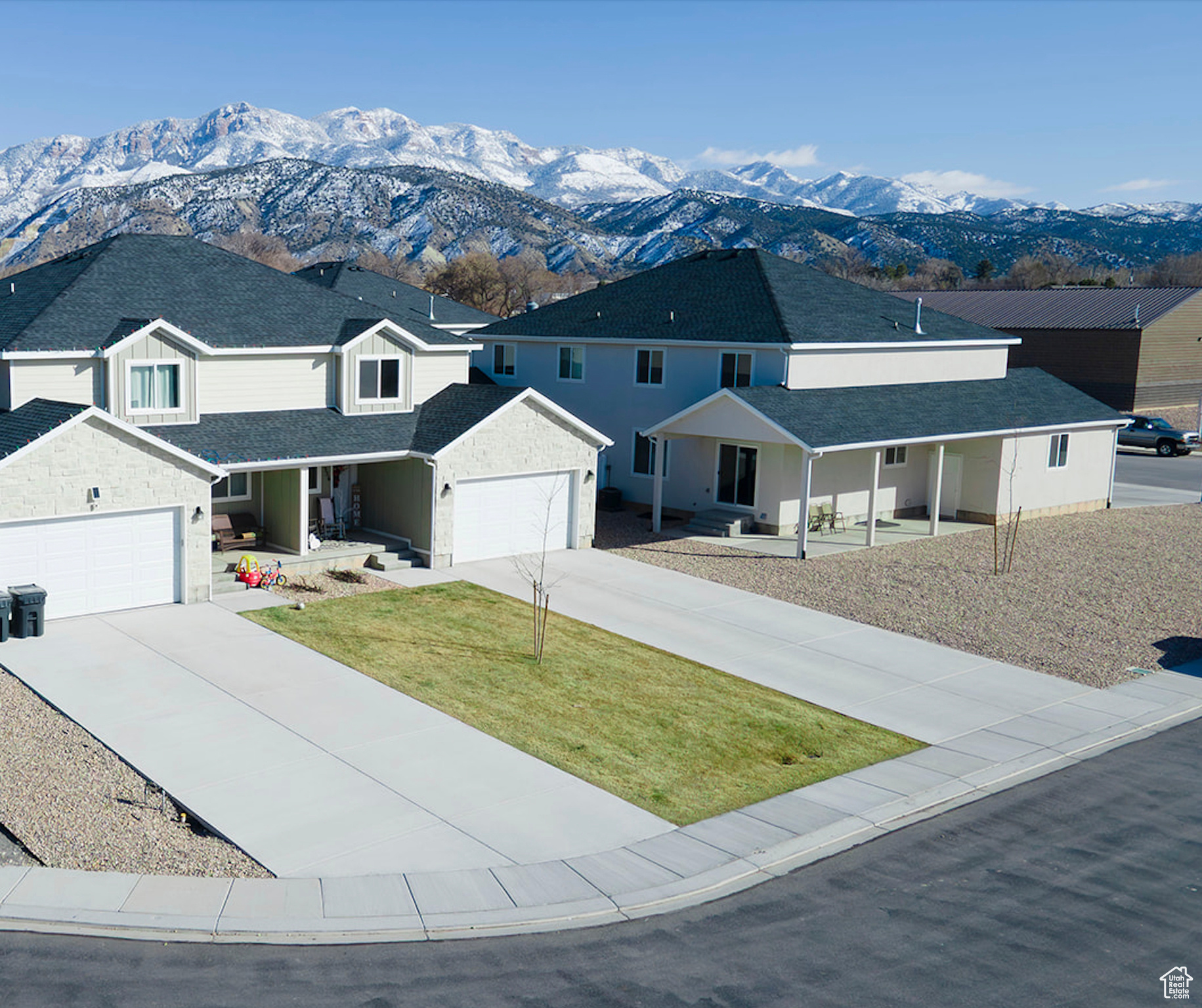 View of front facade featuring covered porch, a mountain view, and concrete driveway