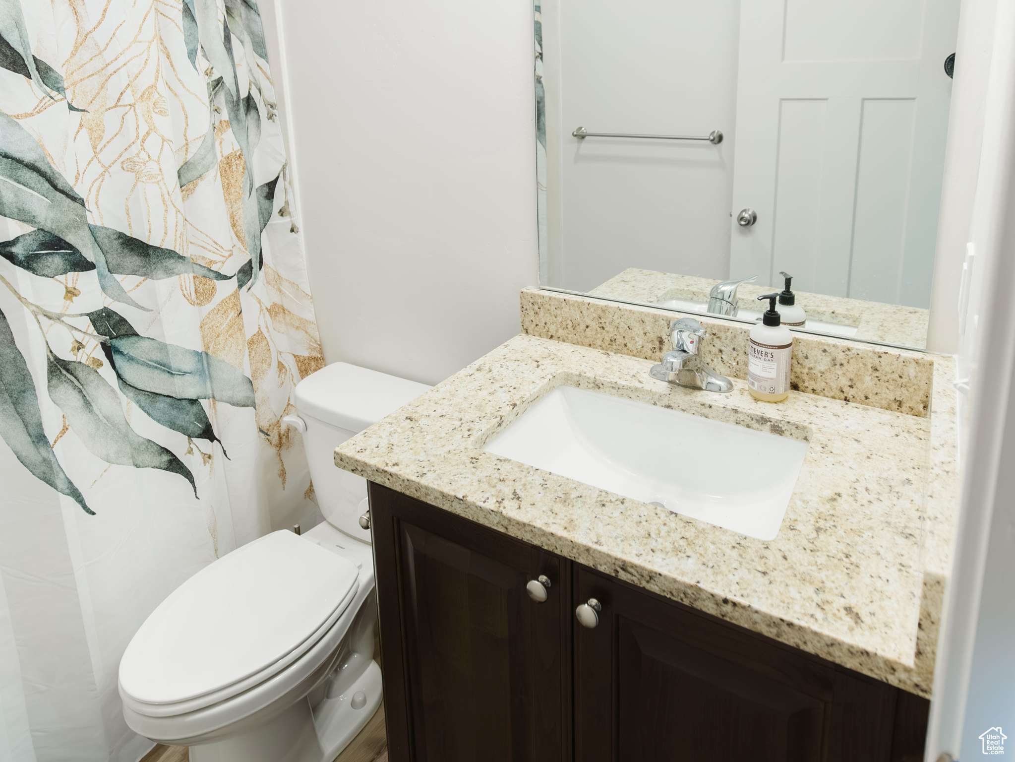 Bathroom with visible vents, vanity, toilet, and wood finished floors