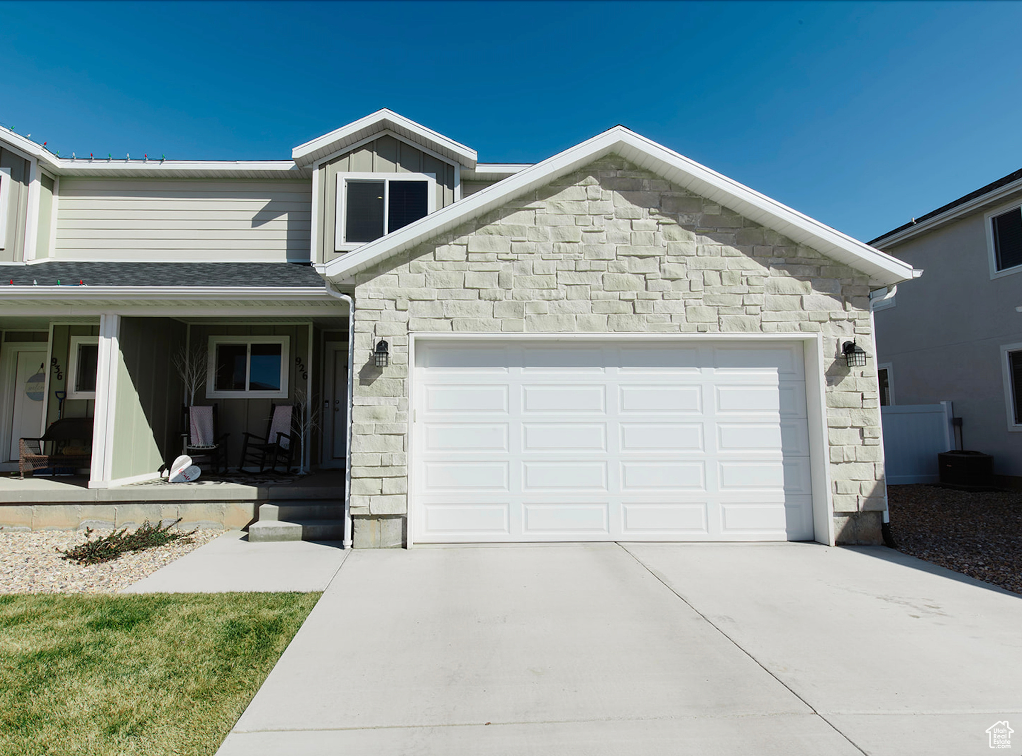 View of front of house with a garage, stone siding, board and batten siding, and concrete driveway