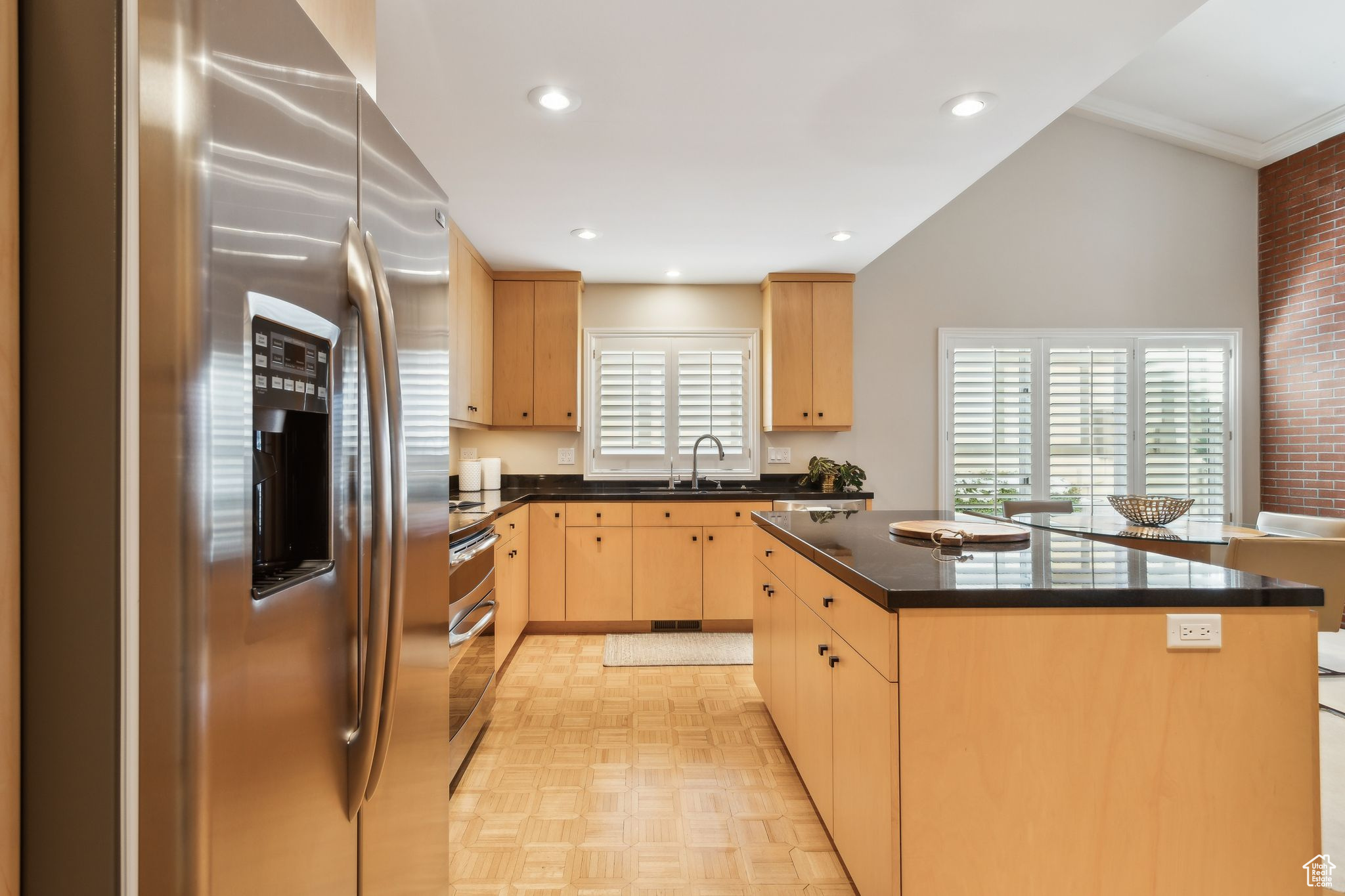 Remodeled kitchen with custom cabinetry, honed black counters and stainless steel appliances