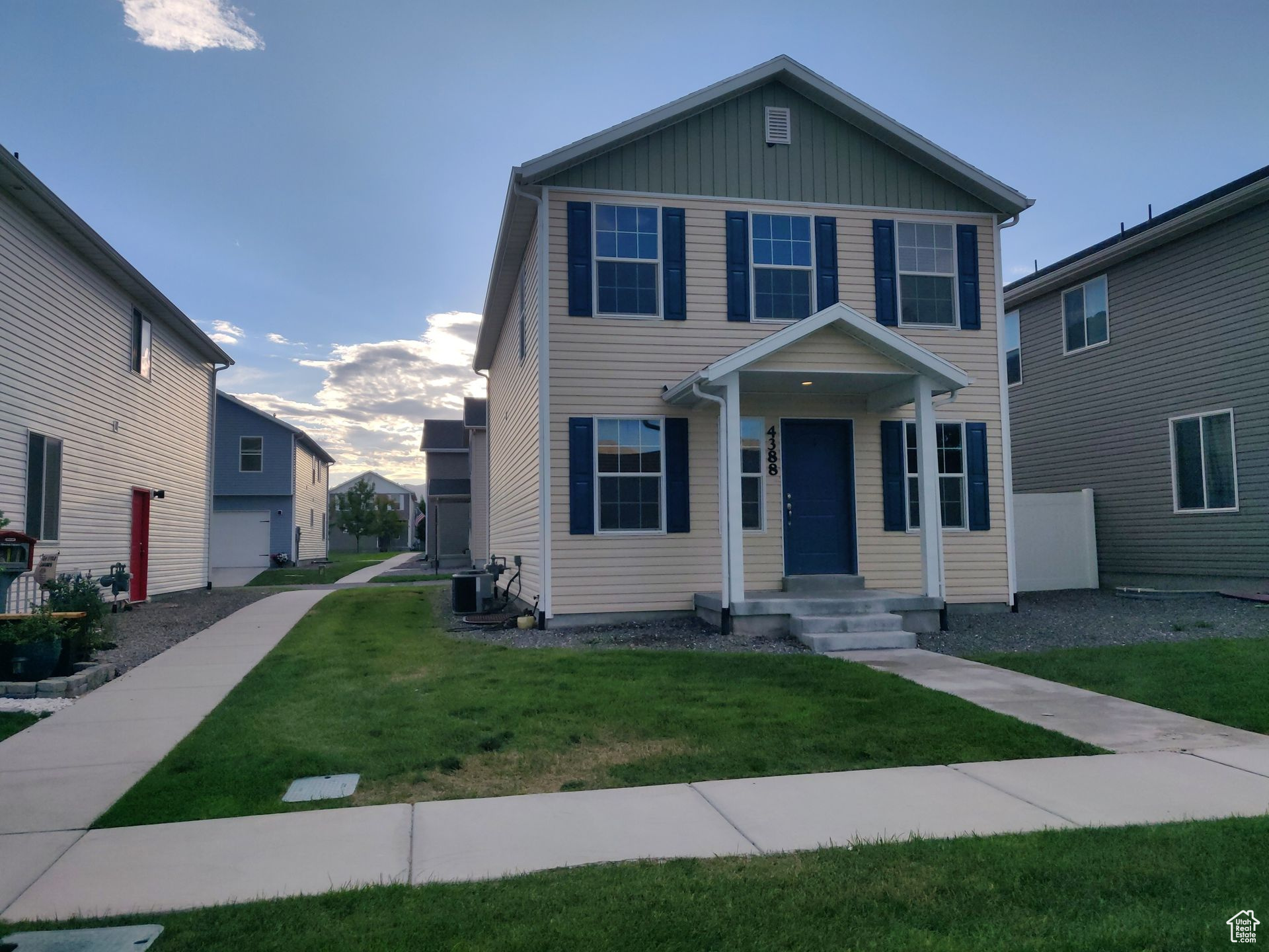 View of front facade featuring central air condition unit, board and batten siding, and a front lawn