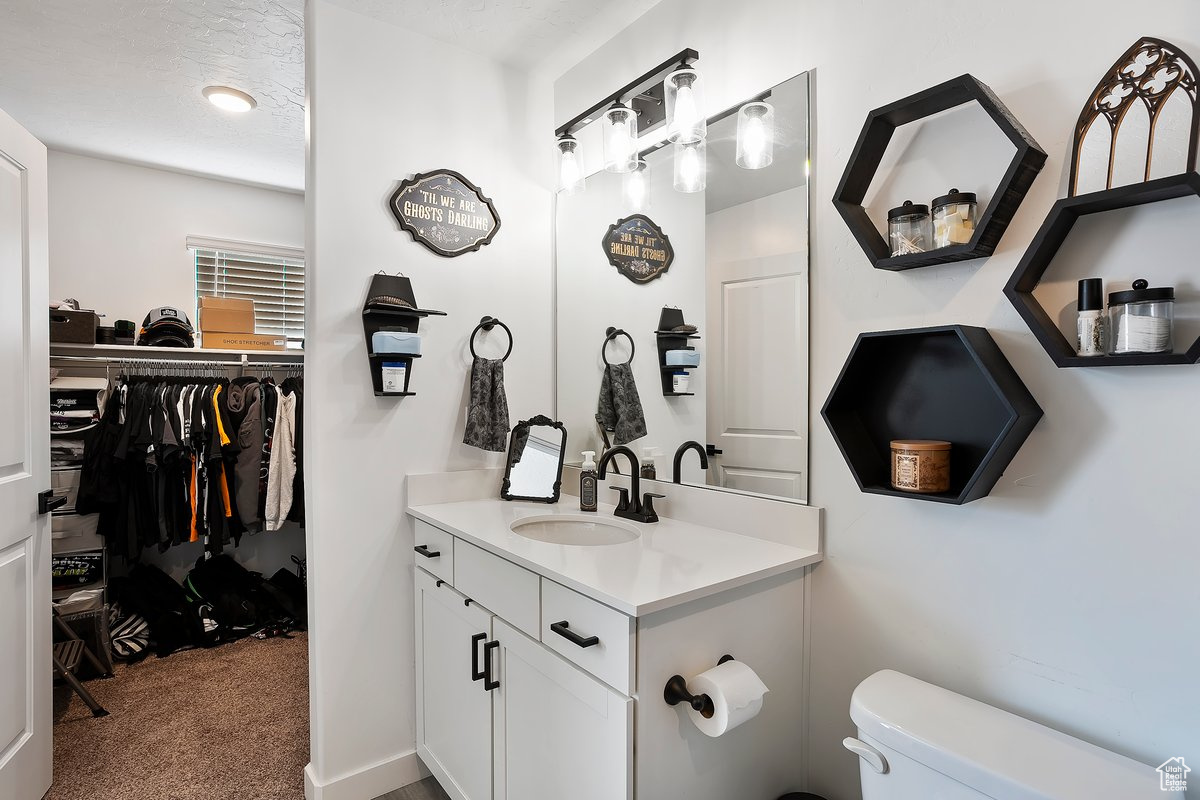 Bathroom featuring toilet, a textured ceiling, and vanity