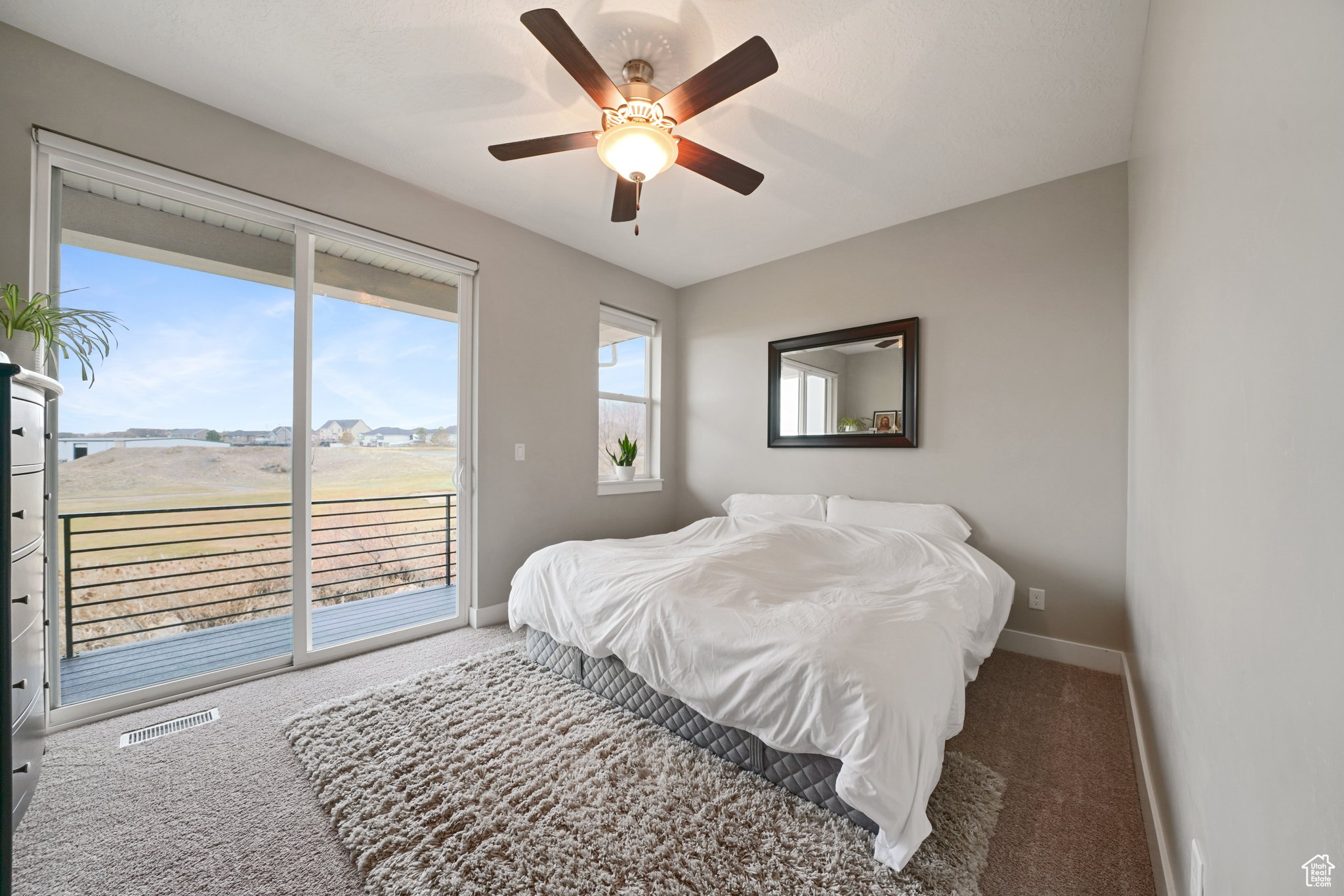 Carpeted bedroom featuring access to exterior, visible vents, ceiling fan, and baseboards