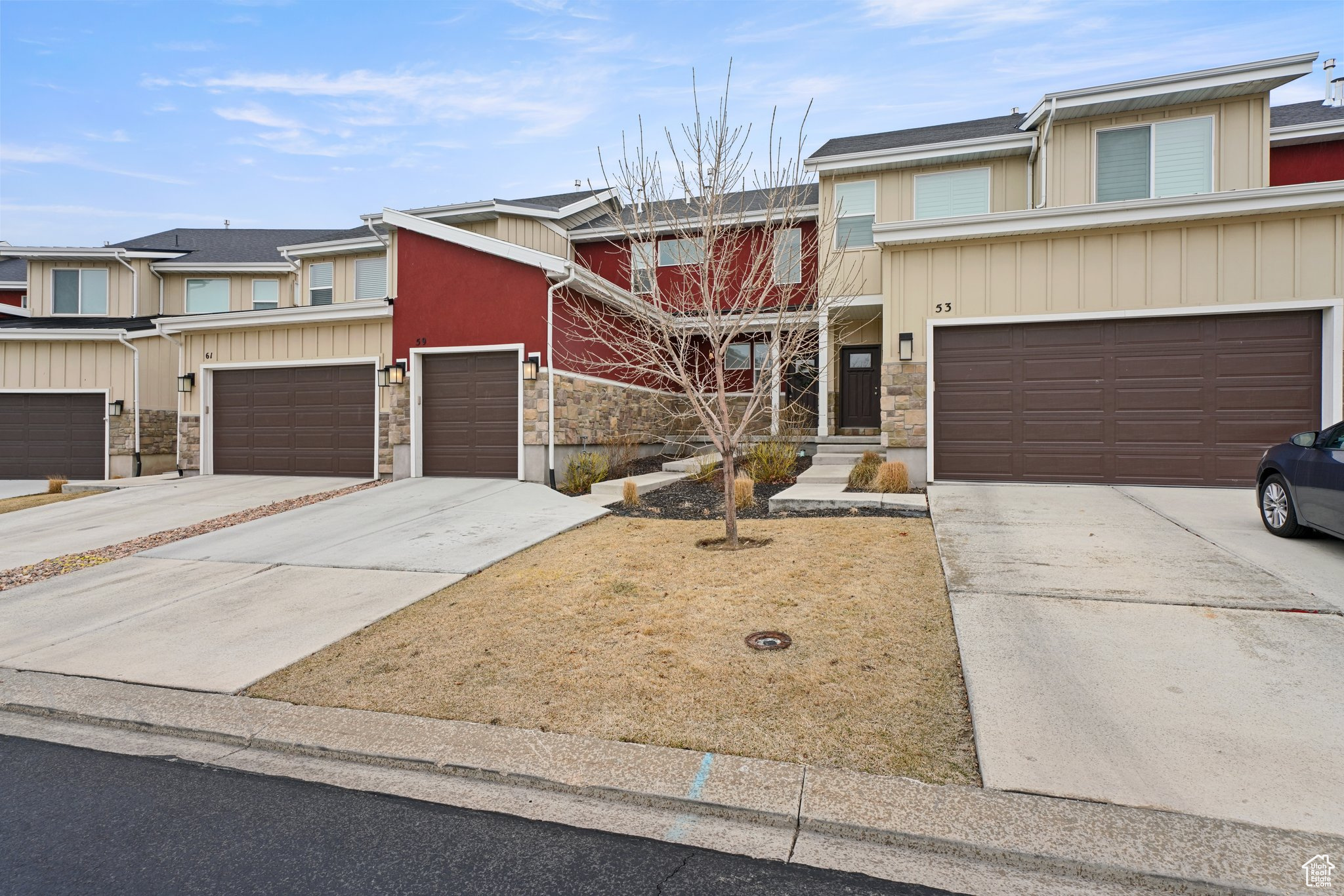 Townhome / multi-family property with stone siding and concrete driveway