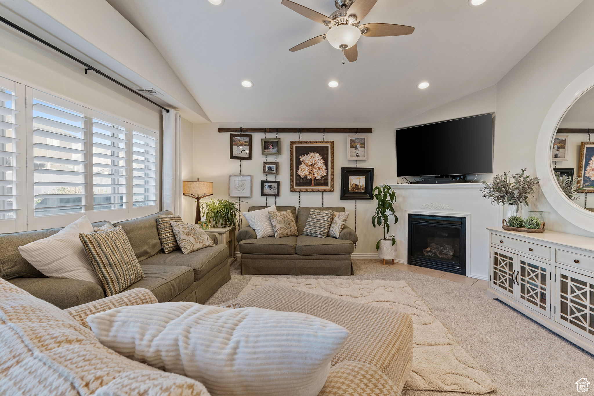 Family room featuring vaulted ceilings, can lighting, plantation shutters, gas fireplace and abundant natural light.