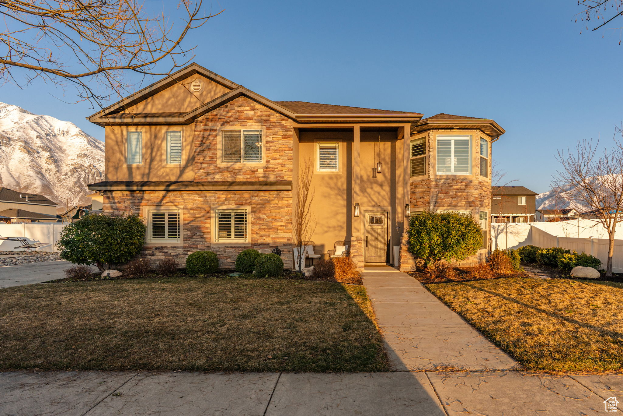 View of the front of the home looking east. Gorgeous and well maintained landscaping.