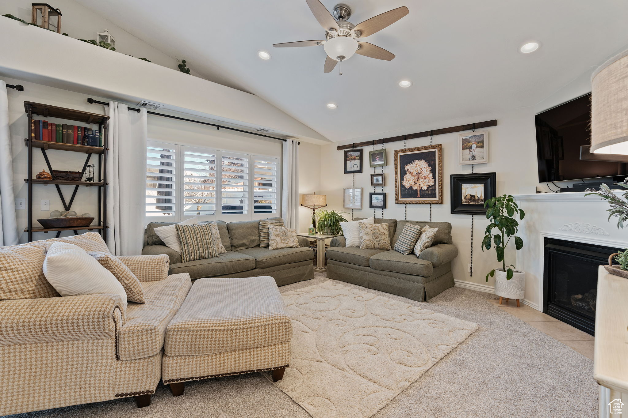 Family room featuring vaulted ceilings, can lighting, plantation shutters, gas fireplace and abundant natural light.