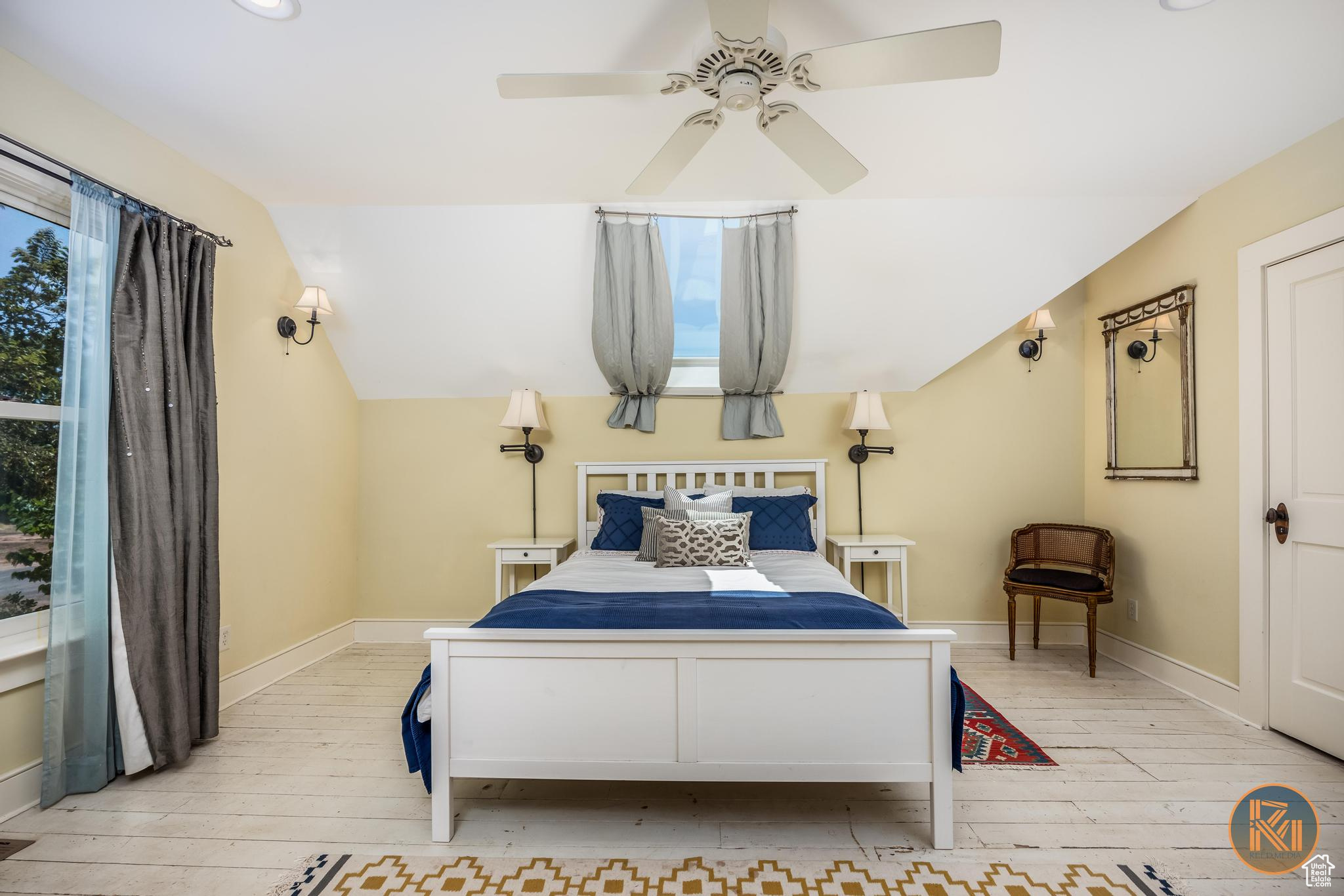 Bedroom with light wood-style floors, vaulted ceiling, baseboards, and a ceiling fan