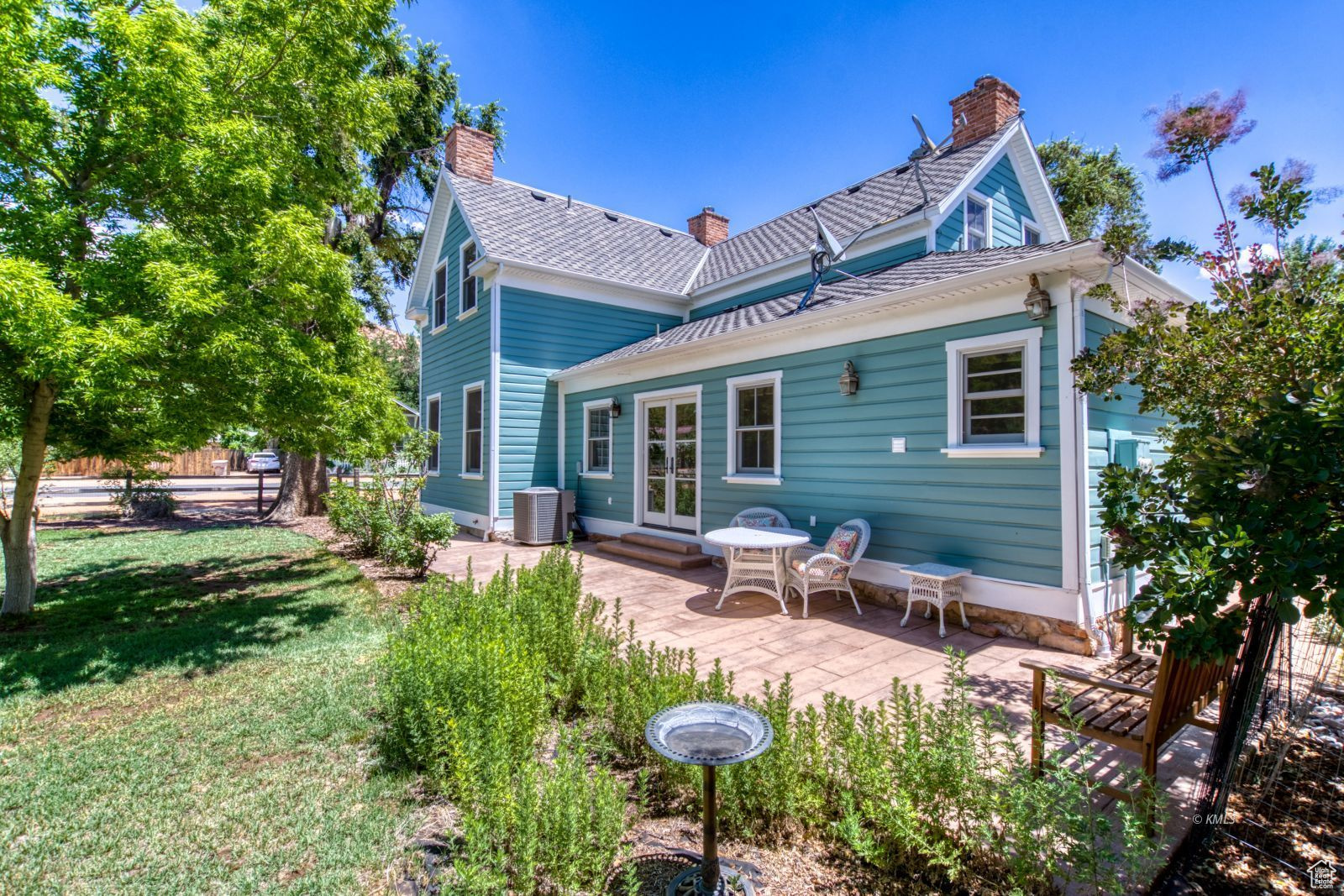 Rear view of property featuring french doors, a patio, a chimney, a yard, and central air condition unit
