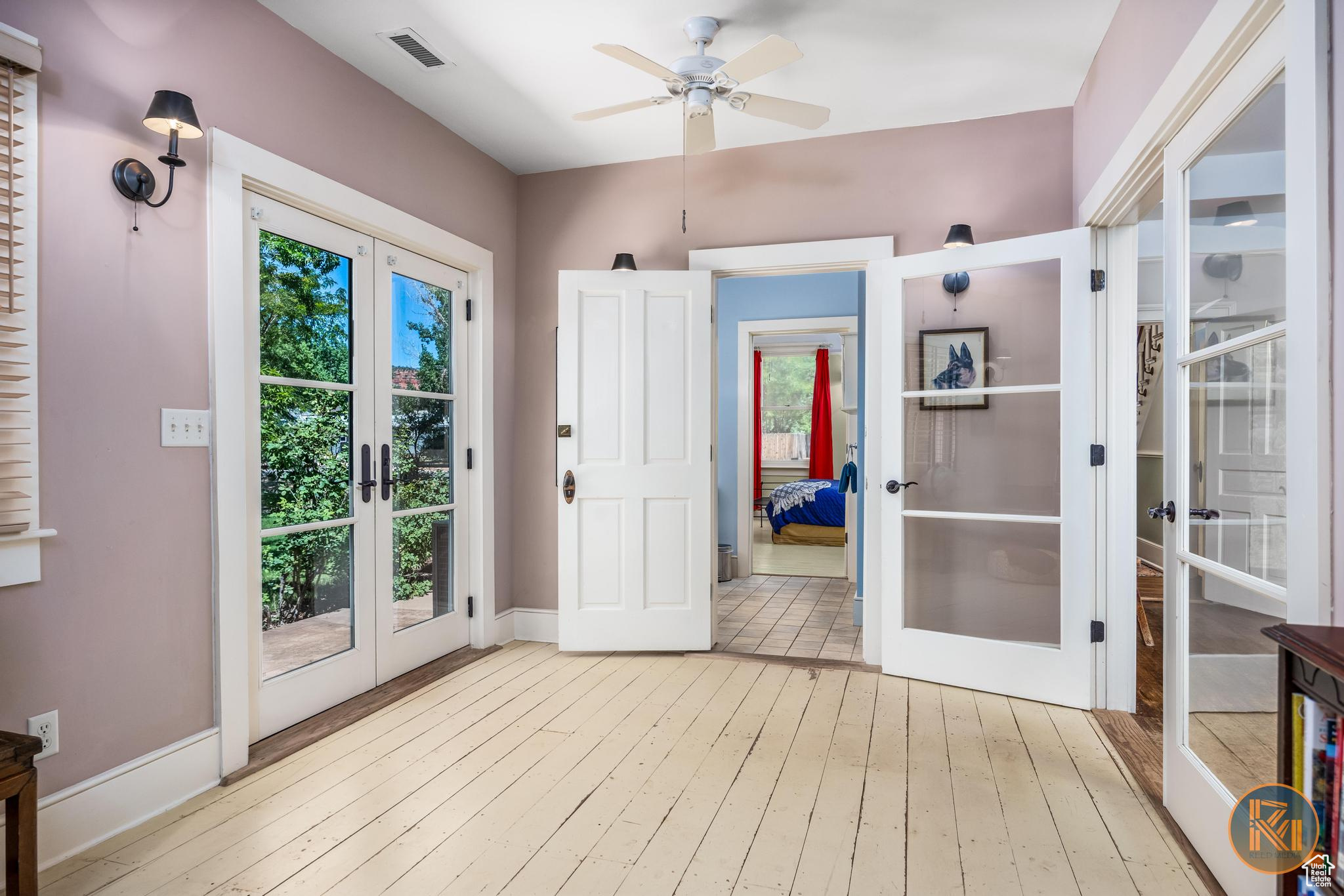 Entryway featuring ceiling fan, hardwood / wood-style flooring, visible vents, baseboards, and french doors